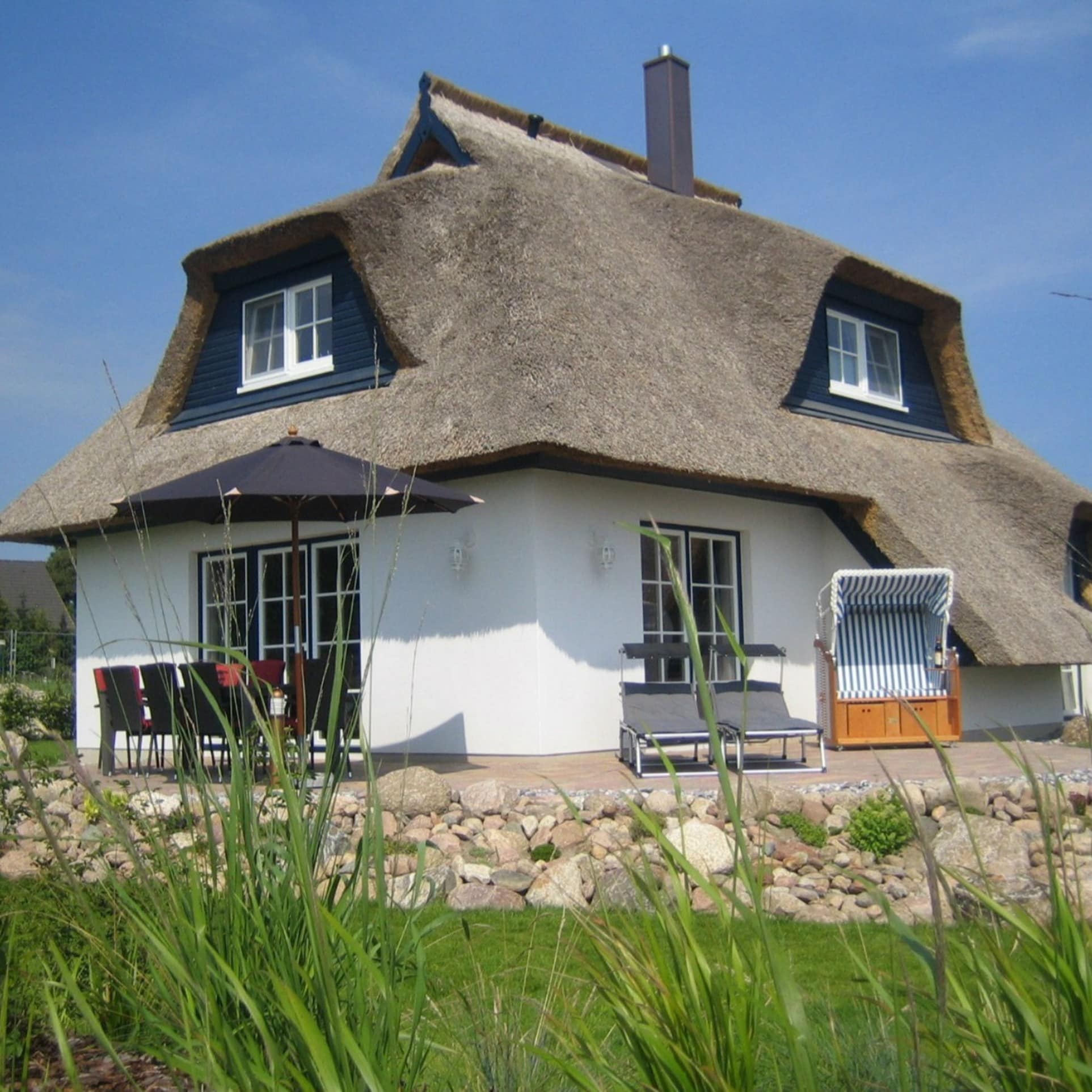 Blick auf einen Bungalow in Heringsdorf mit Sitzgelegenheiten und Strandkorb auf der Terrasse