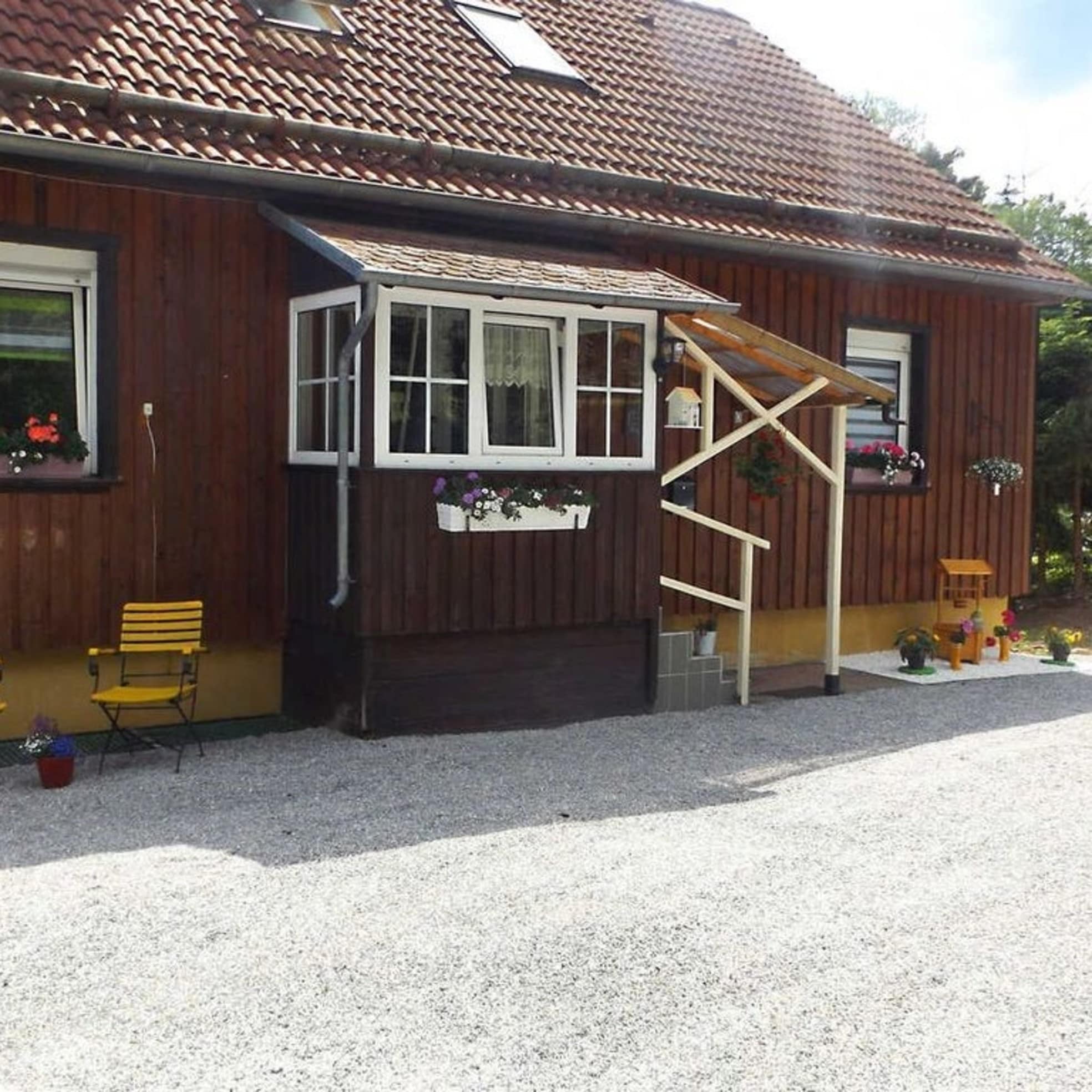 Chalet aus Holz im Harz mit gelben Stühlen