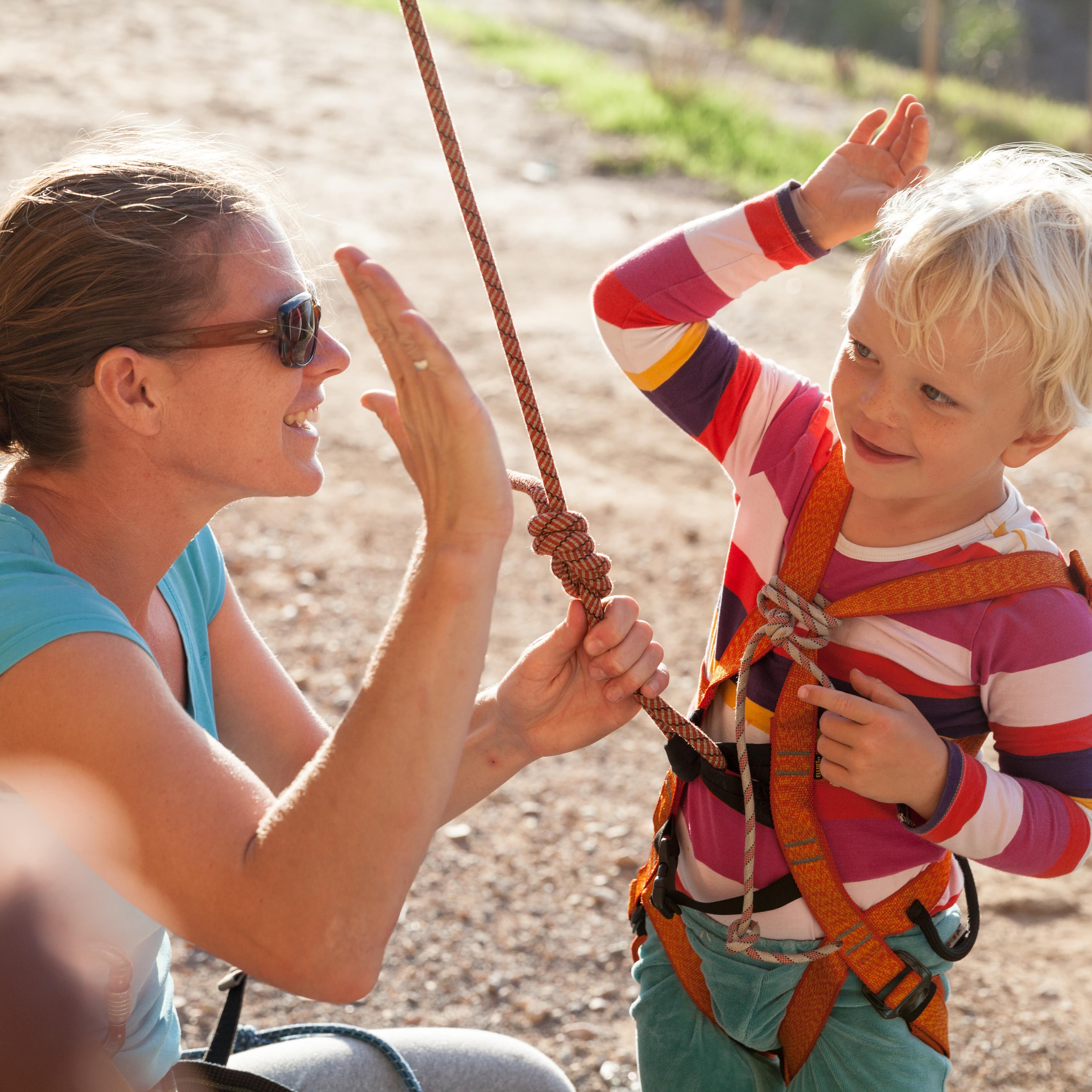 Mutter und Kind beim Klettern geben sich High-Five.