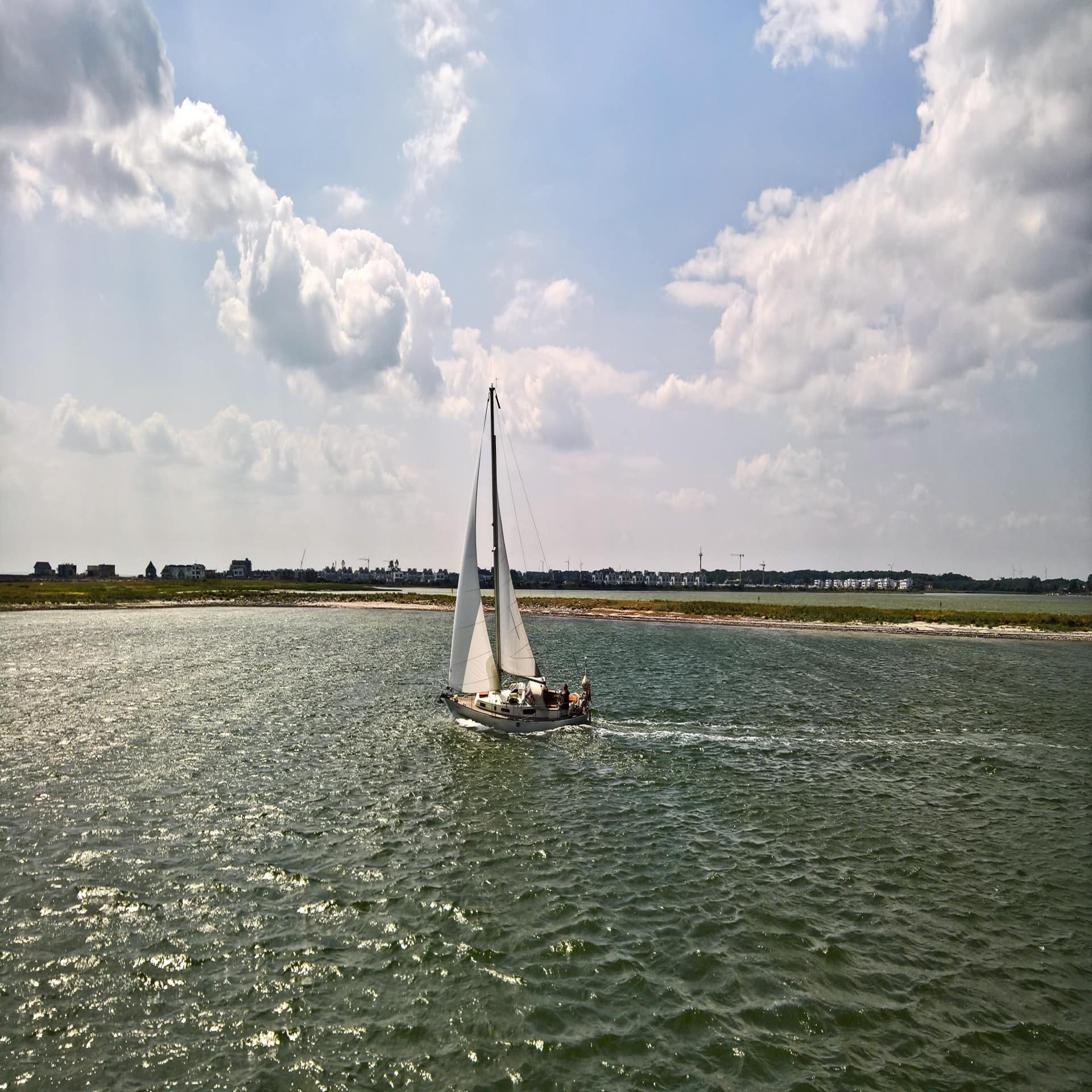 Ein kleines Segelboot mit einem Masten schippert auf der Schlei.