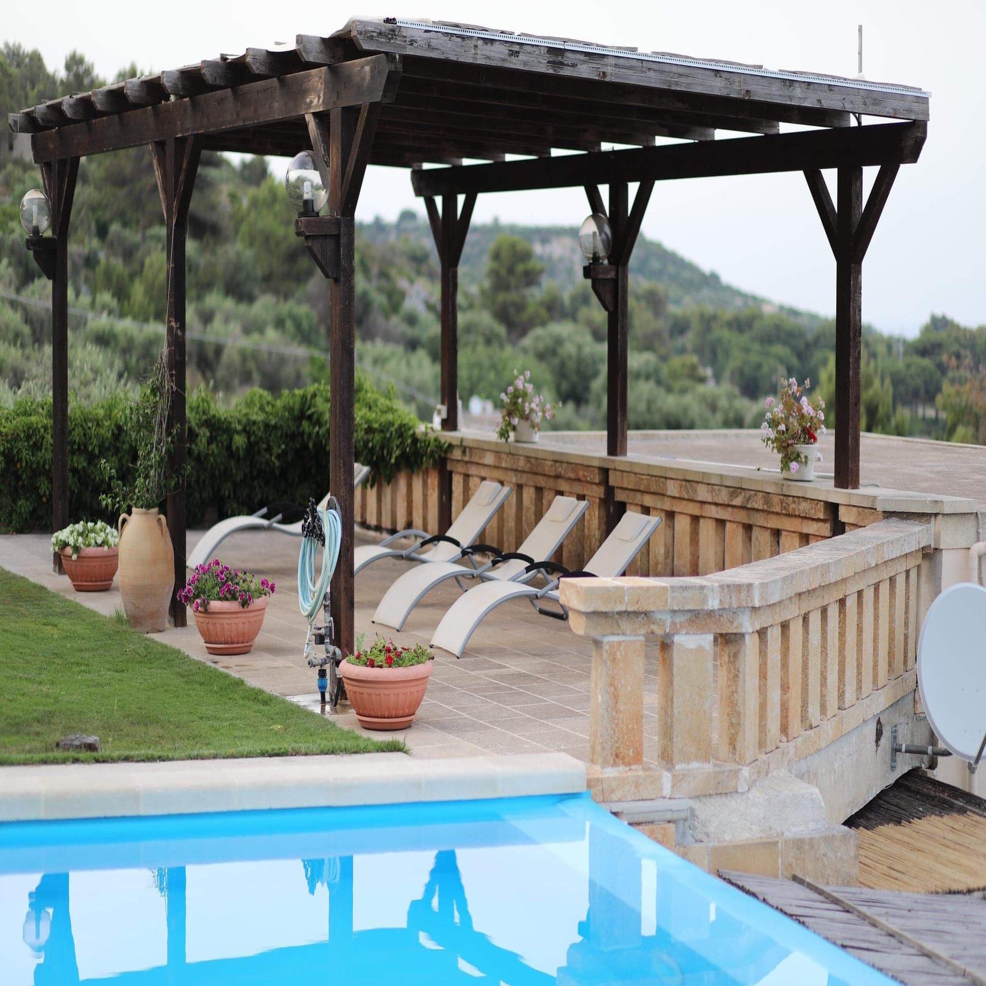 Sonnenliegen am Pool auf nostalgischer Terrasse