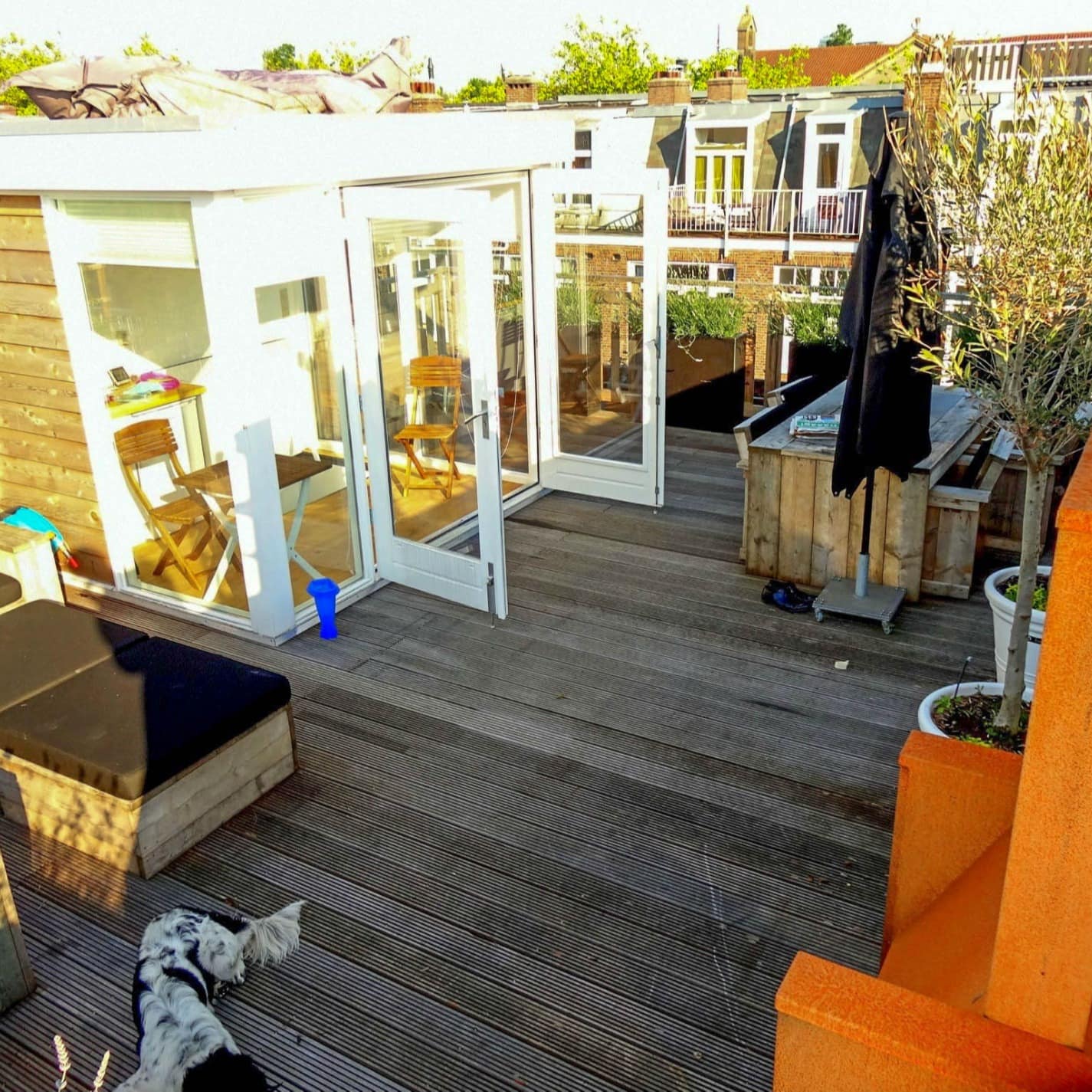 Blick auf eine Dachterrasse mit Sitzgelegenheiten und Wintergarten