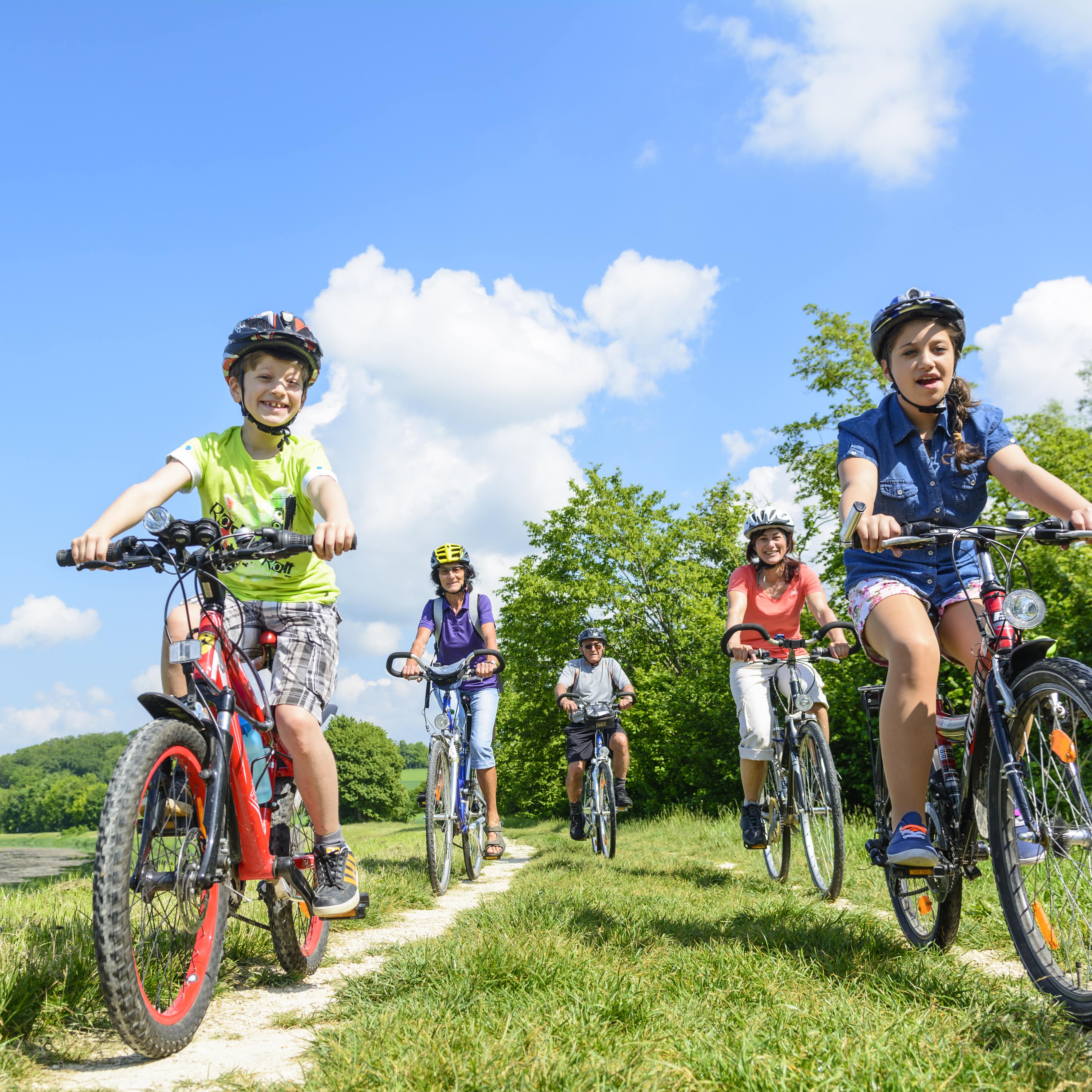 Familie mit Kindern und Großeltern auf Fahrradtour am See.