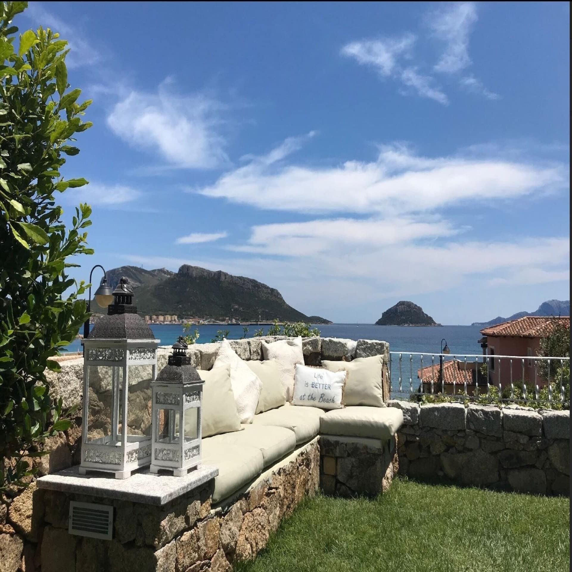 Garten mit Kuschelsofa mit Ausblick auf das Mittelmeer auf Sardinien. Die Sonne scheint. 