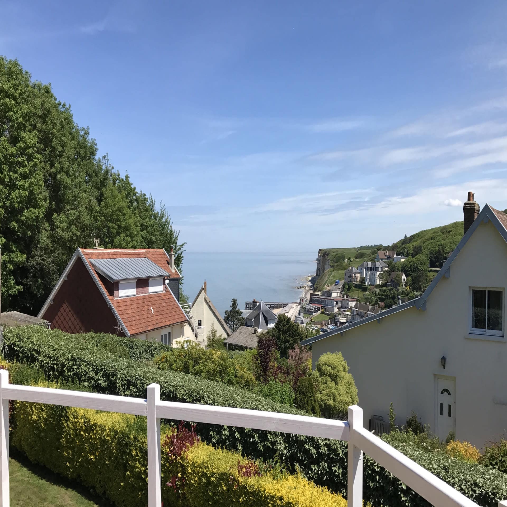 Blick von einem Balkon über einen Ort und das Meer in der Normandie.