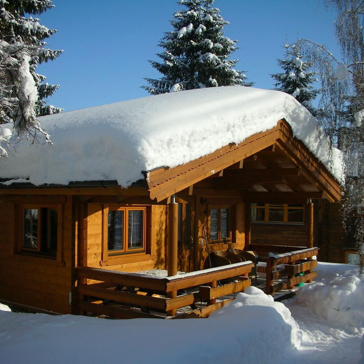 Ferienhaus in Österreich in einem Skigebiet – gemütliche Alpenhütte aus Holz in dickem Schnee