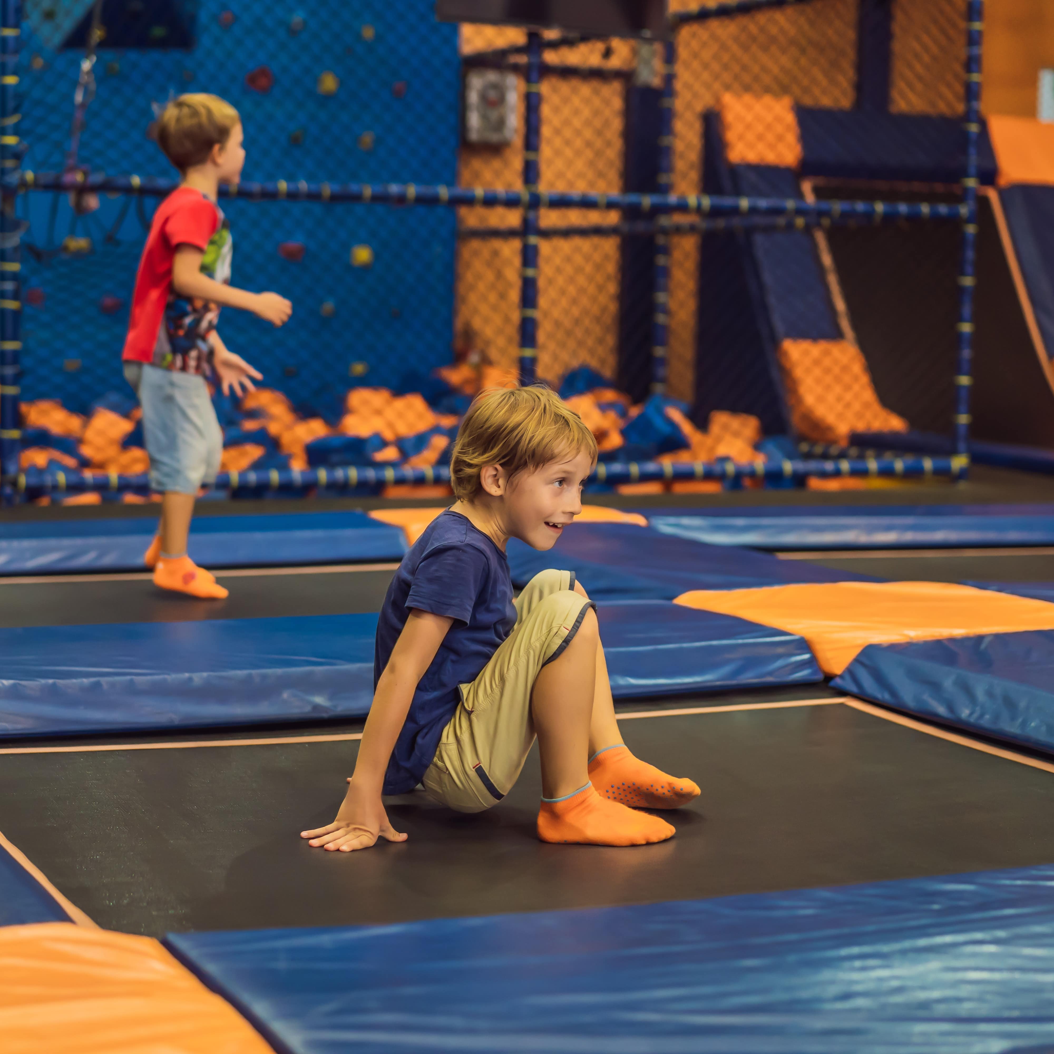 2 Jungen in einem Trampolinpark, beide mit orangenen Rutschesocken.