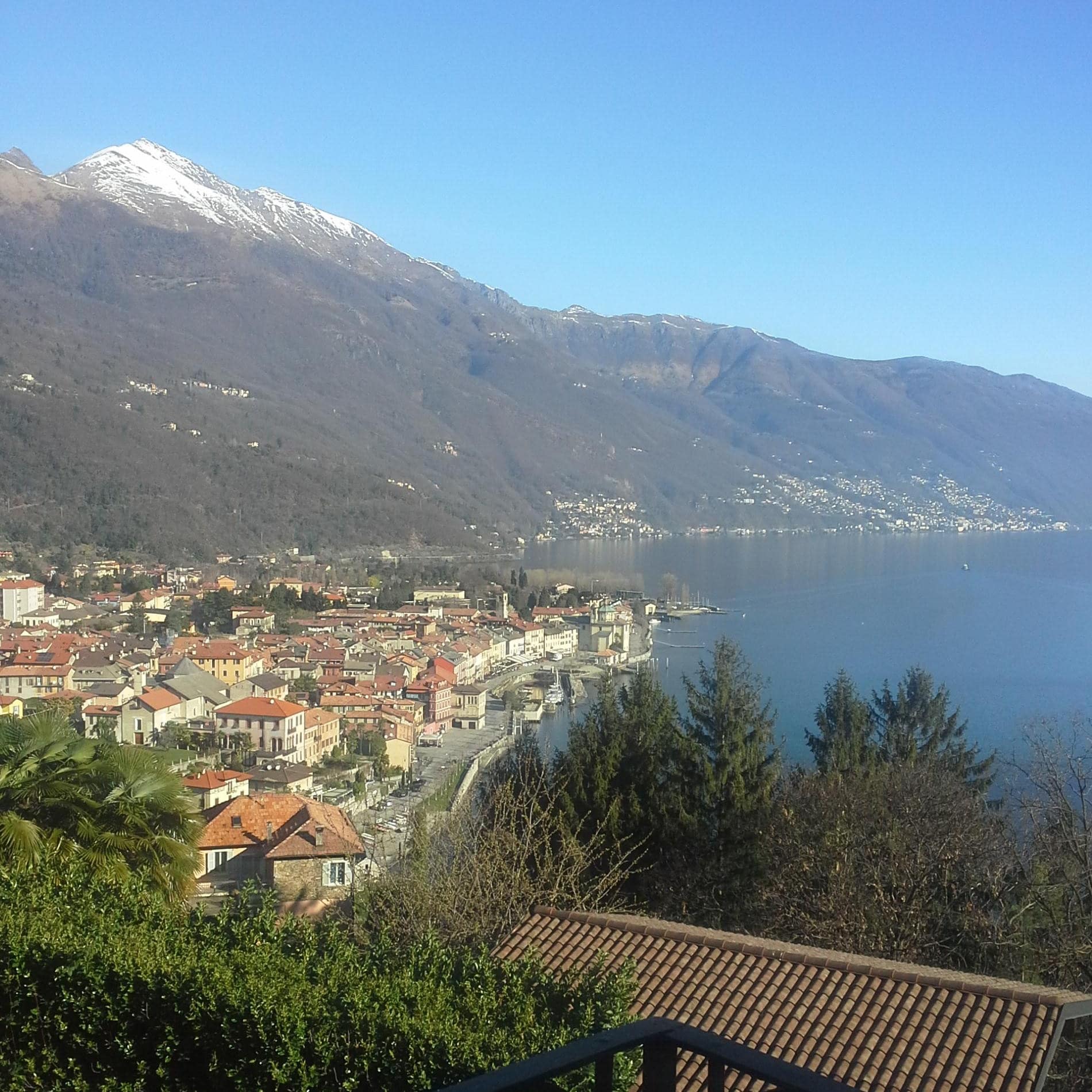 Am Ufer des Lago Maggiore unter einem schneebedeckten Gipfel liegt die italienische Kleinstadt Cannobio