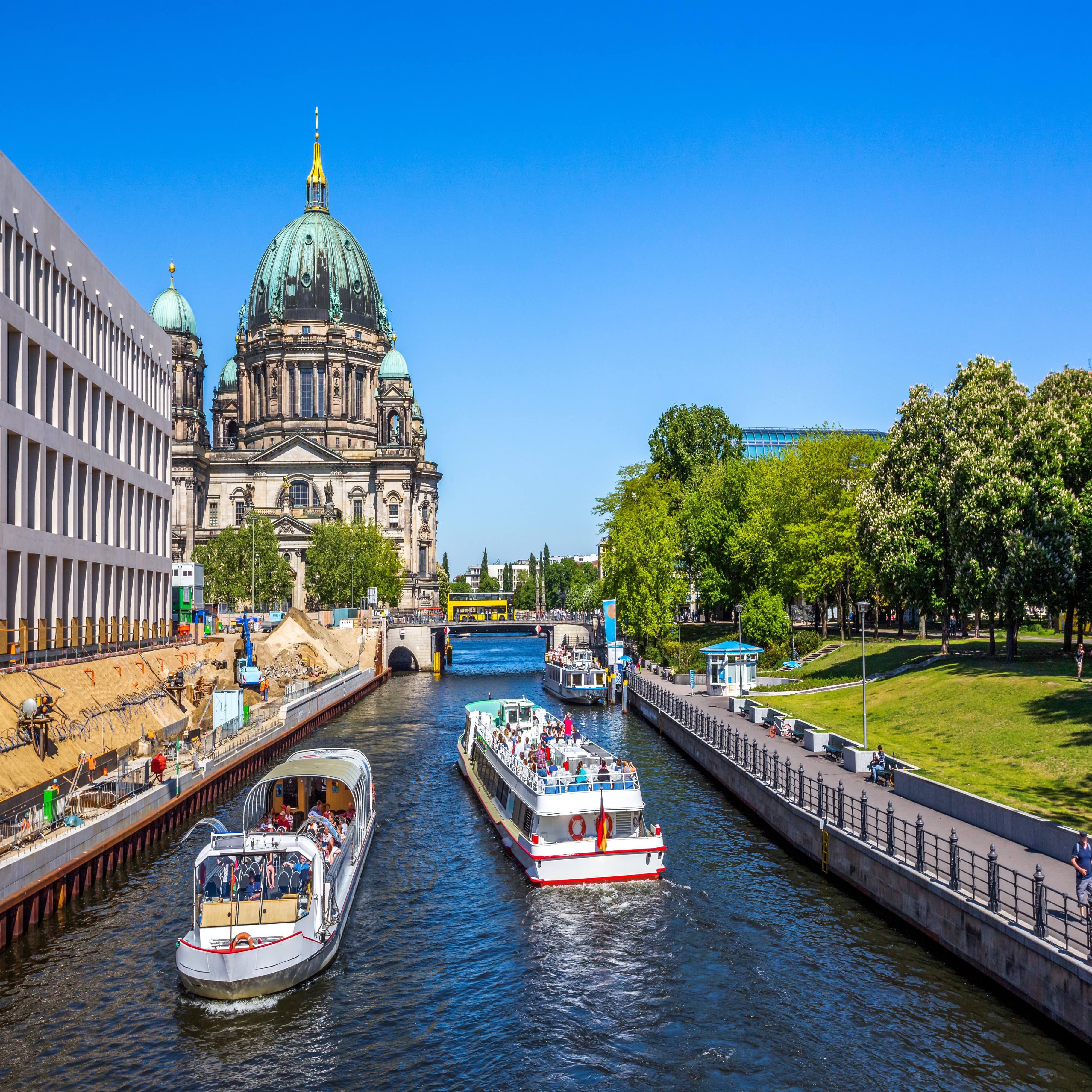 Blick von einer Brücke auf 3 Ausflugsboote auf der Spree. 