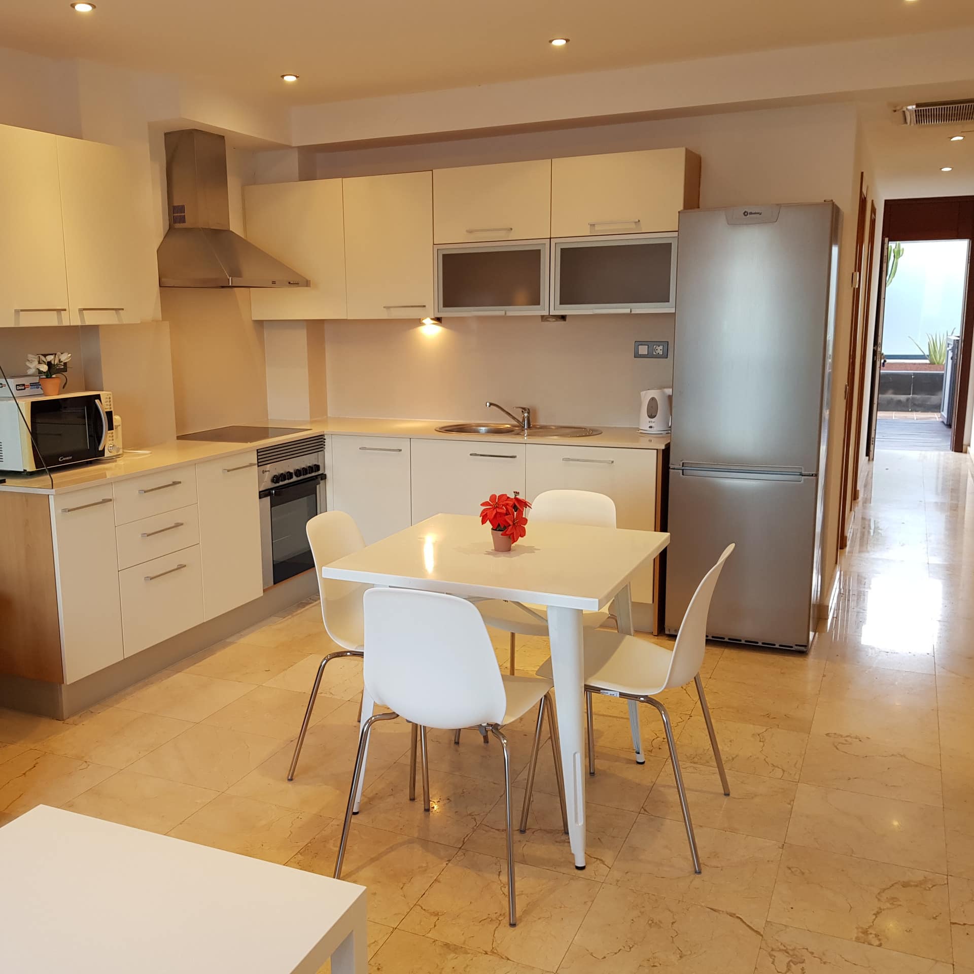 Moderne Ferienwohnung auf Fuerteventura mit großer Wohnküche, Sofa und Couchtisch sowie Balkon mit Blick übers Meer