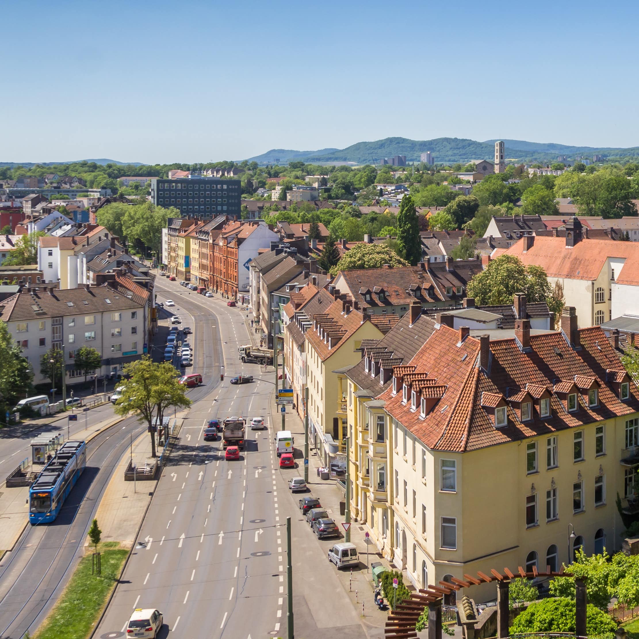 Panoramablick über Kassel: Wohnhäuser, eine Straße und Straßenbahn. 
