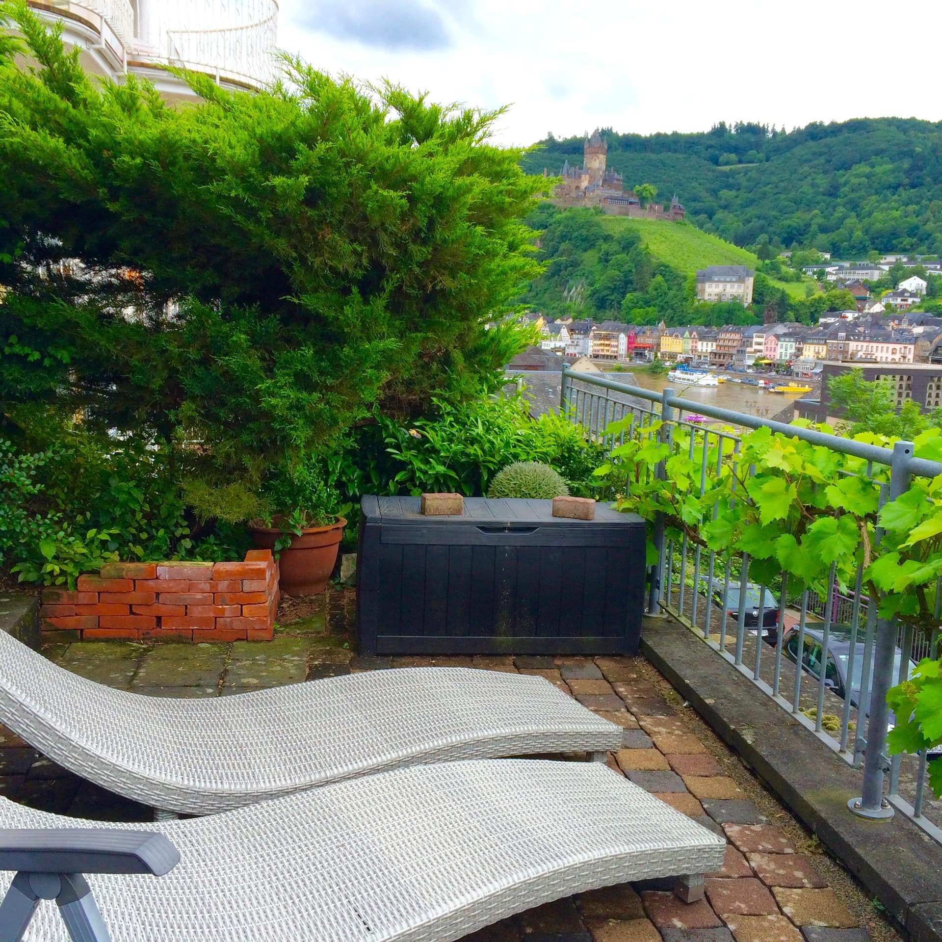 Blick von der Terrasse mit Liegestühlen einer Ferienwohnung in Cochem-Zentrum mit Blick auf die Mosel und die Burg