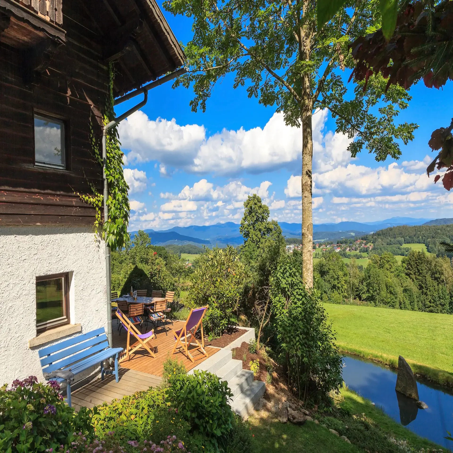 Ecke eines Ferienhauses mit Terrasse und Panoramablick auf die ländliche Umgebung.