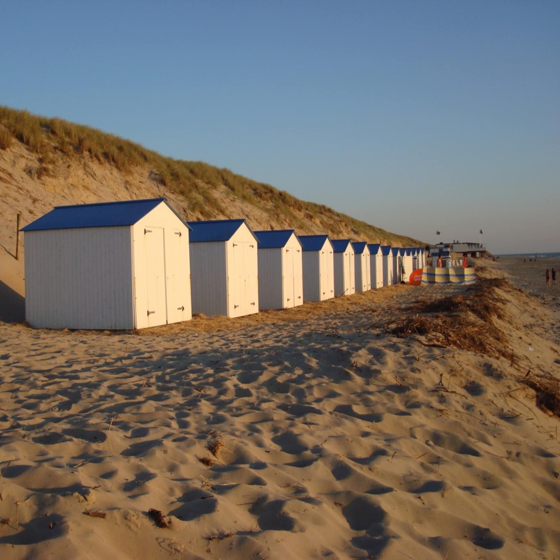 Strandhäuser in der Abenddämmerung am breiten Sandstrand von De Koog