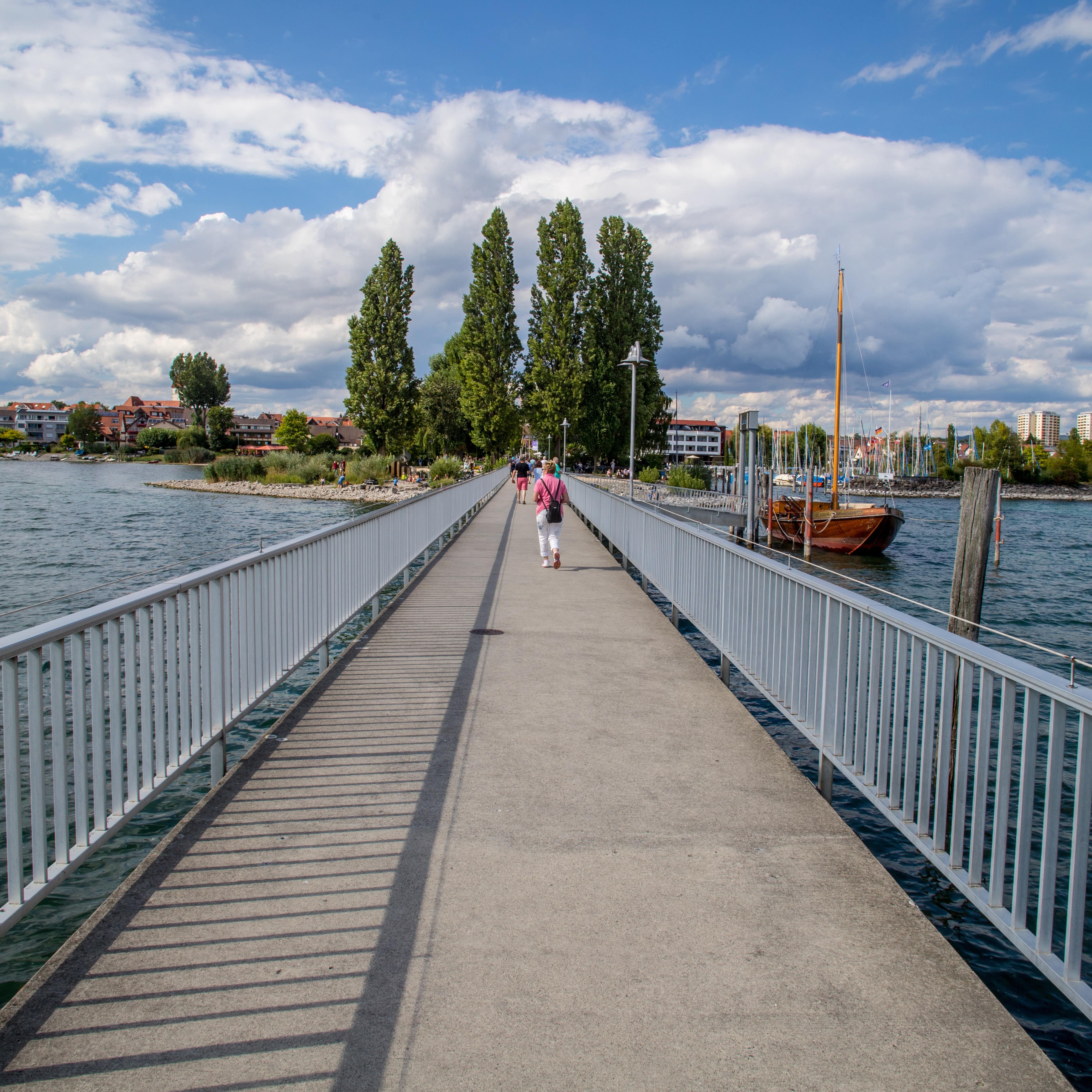 Blick entlang der Seebrücke Immenstaad. Rechts ankert ein Segelboot.