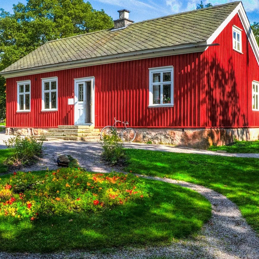 Typisches Sommerhäuschen in Südschweden mit einem Garten, an dem Haus lehnt ein Fahrrad