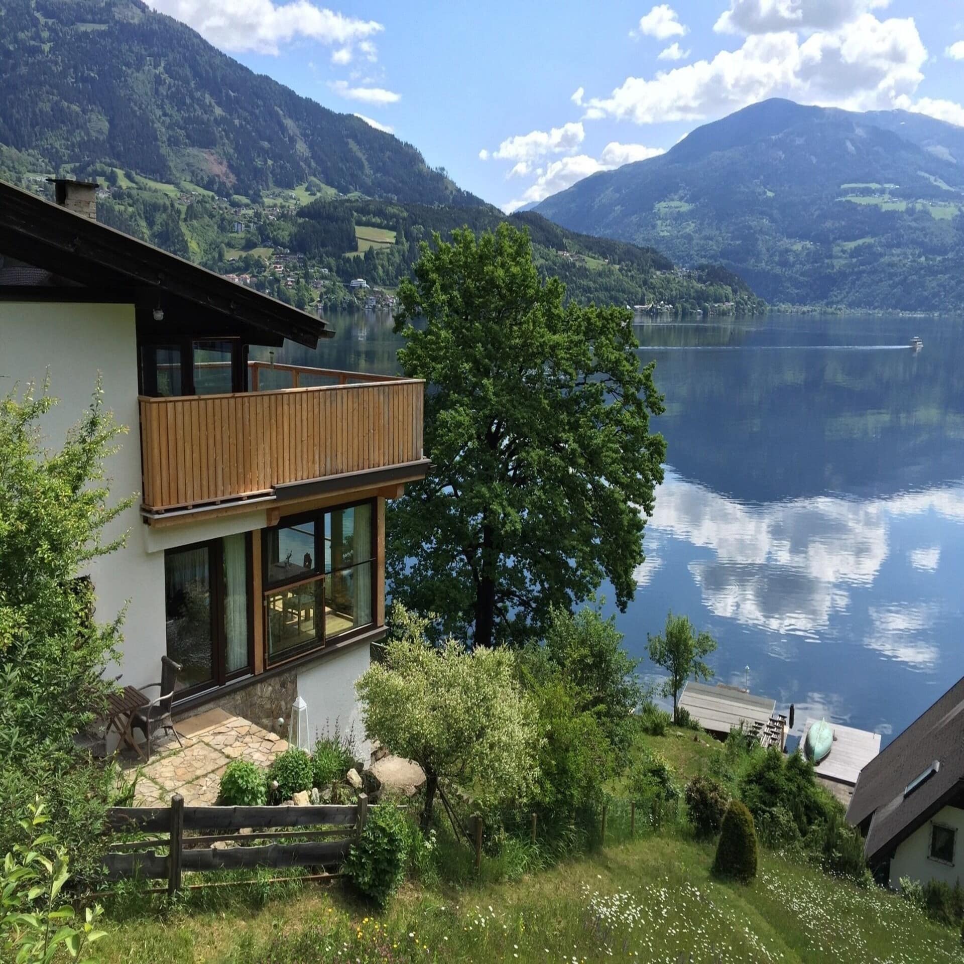 Ein Haus am Ufer des Millstättersees mit Blick auf die Berge. 