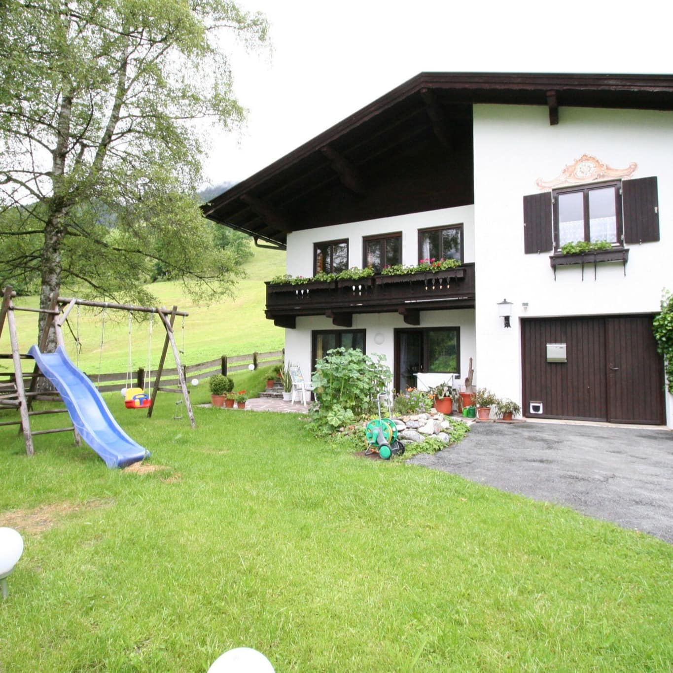 Garten mit Spielgeräten für Kinder einer Ferienwohnung in Ellmau