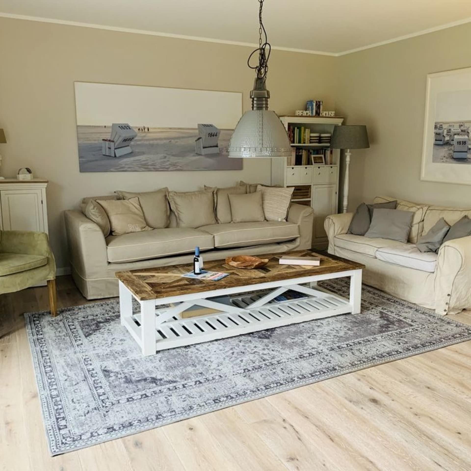 Wohnzimmer mit heller, maritimer Einrichtung einer Ferienwohnung in Sankt Peter-Ording