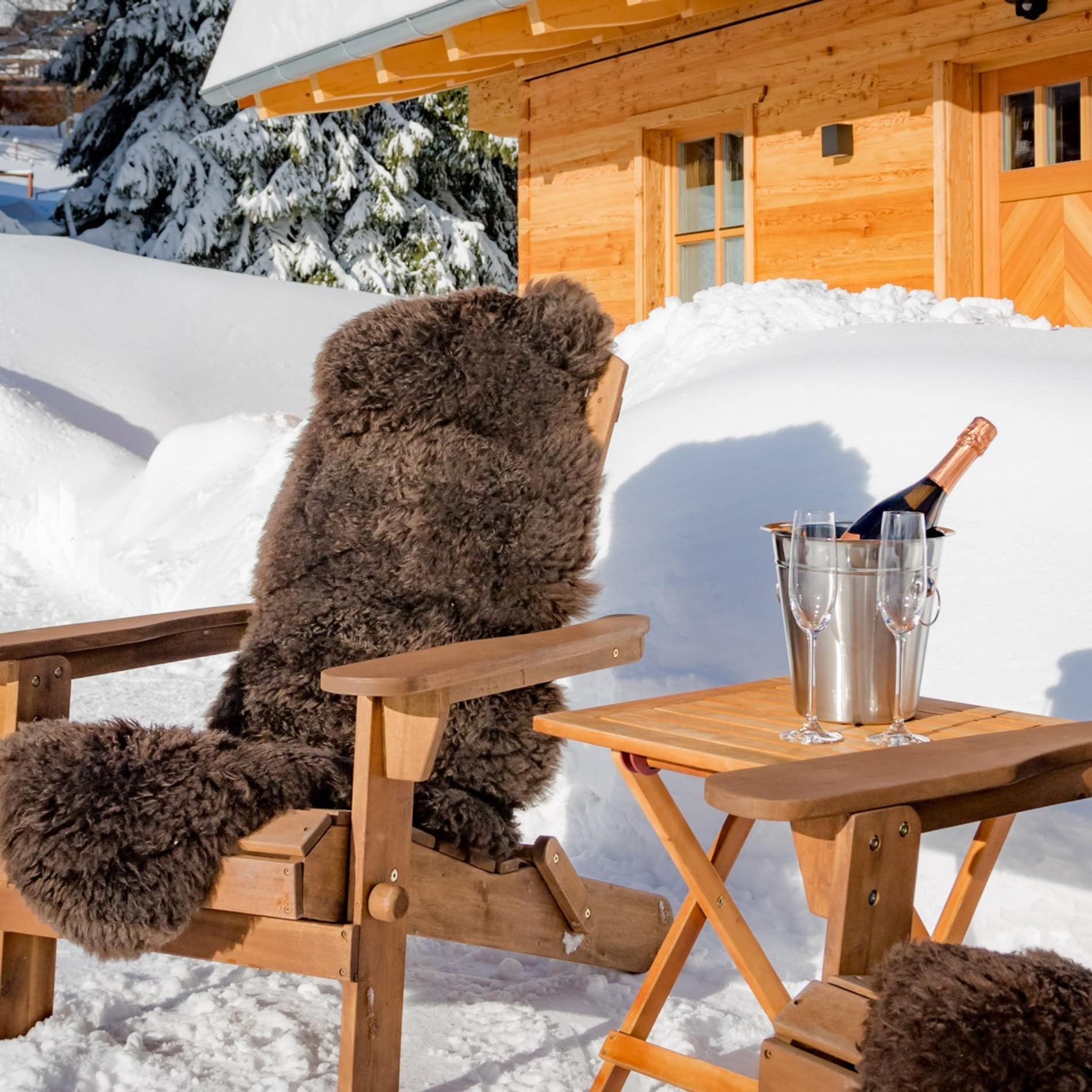 Champagner für zwei vor einem schneebeckten Luxus-Chalet im Bayerischen Wald
