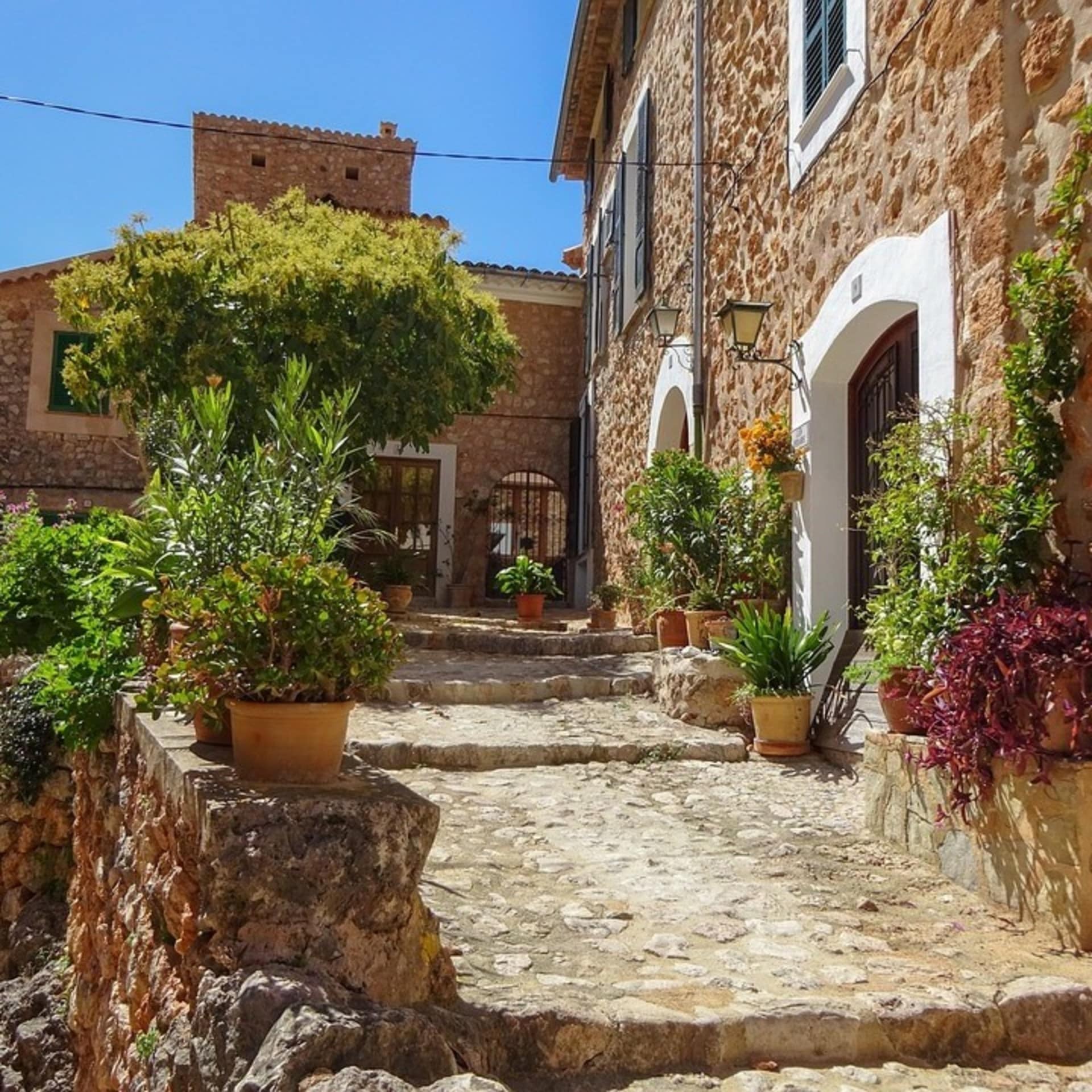 Die rustikalen Hausfassaden und die Blumenkübel verleihen mediterranes Flair