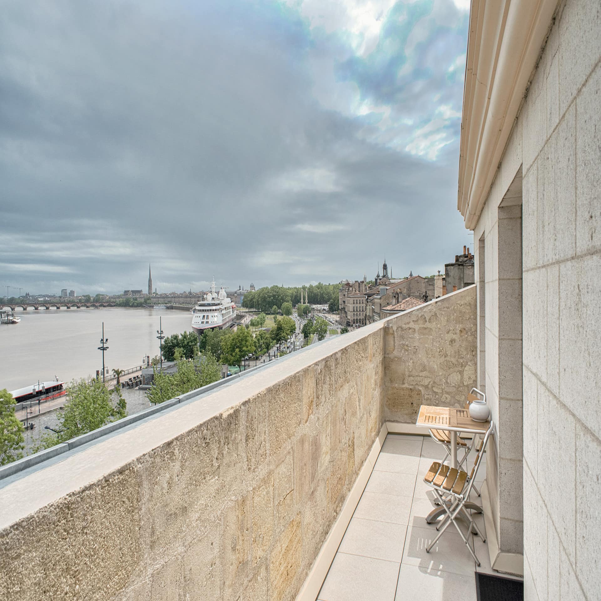 Blick von einem Balkon auf den Fluss mit großem Schiff und die Umgebung.