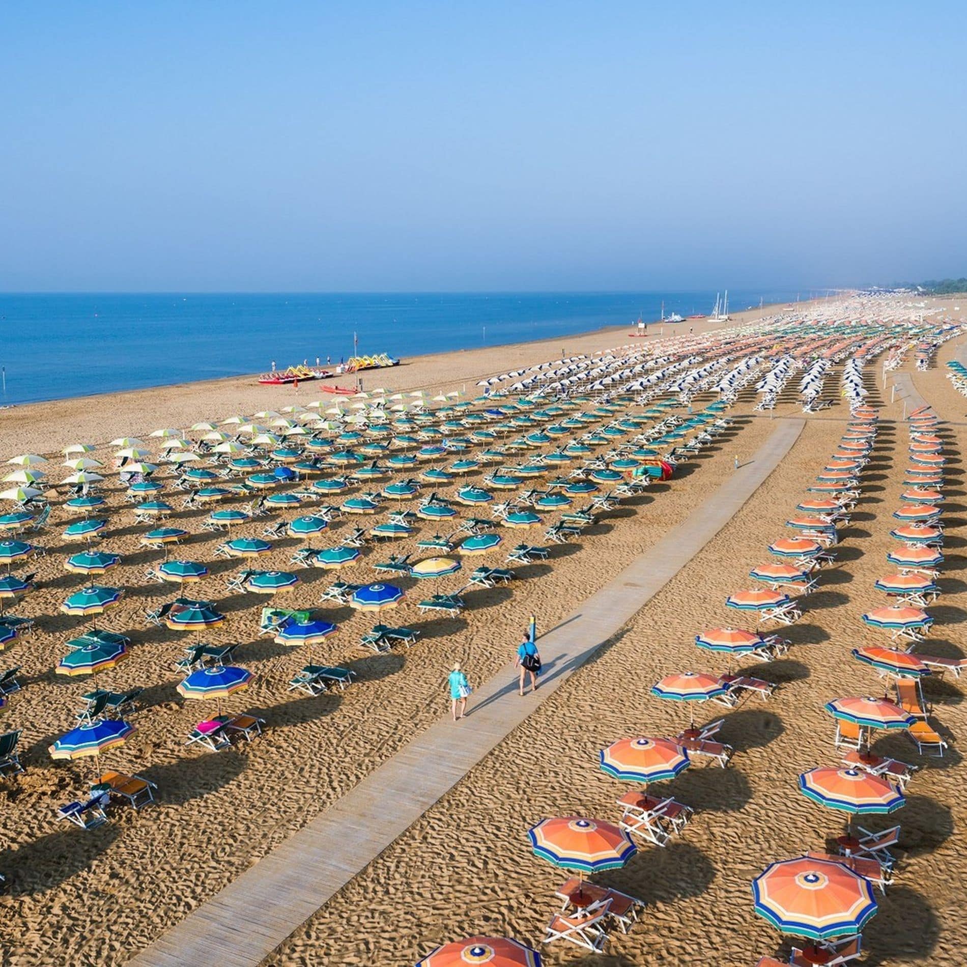 Farbige Sonnenschirme zieren über Kilometer den Sandstrand an der Adria in Bibione Spiaggia