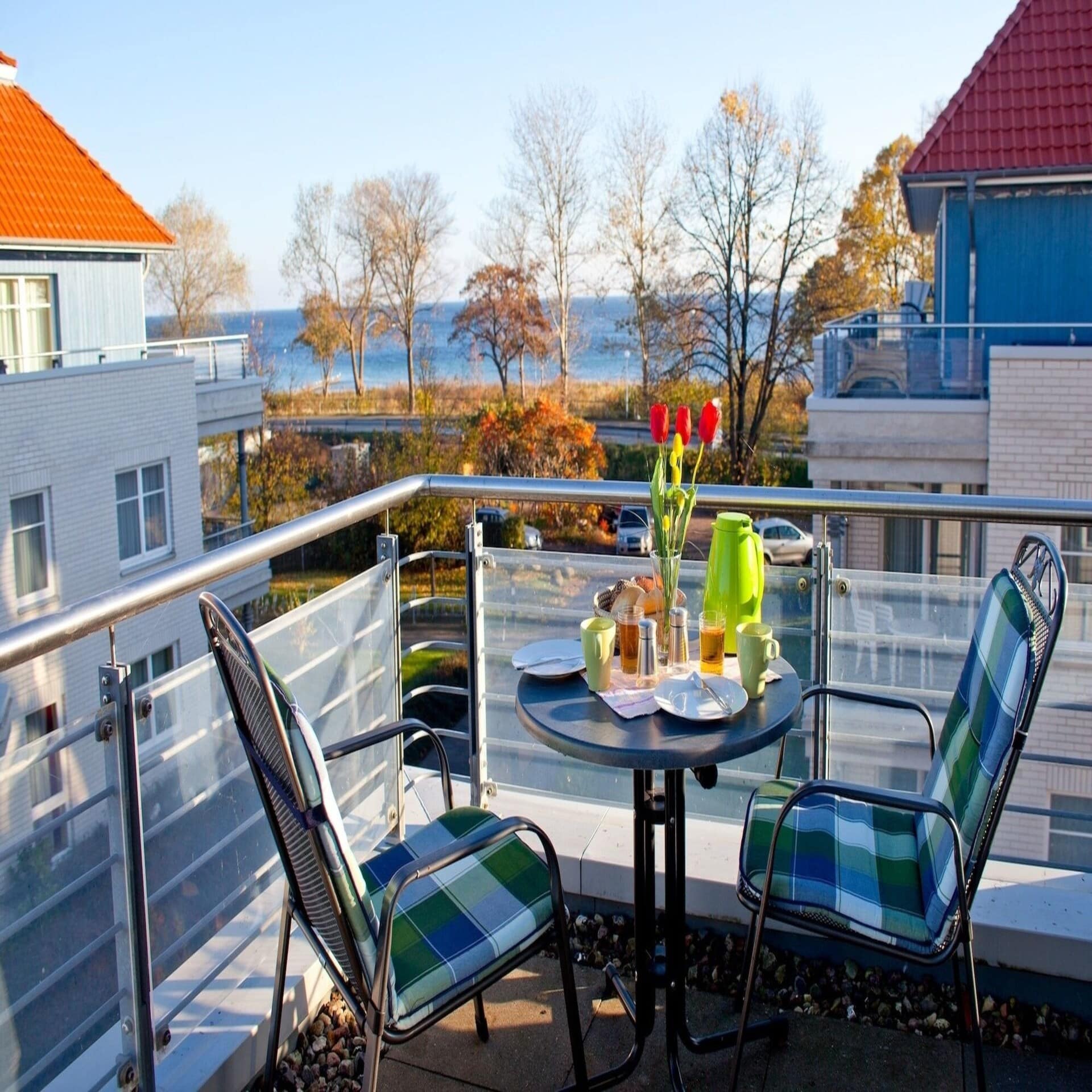 Gedeckter Frühstückstisch für 2 auf einem Balkon mit Meerblick. Es ist Herbst.