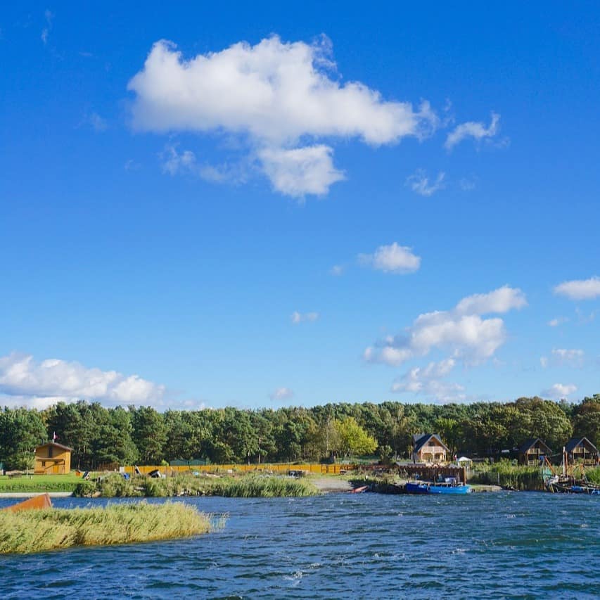 Blick vom Wasser auf die Ostseeküste mit Wäldern und Häusern