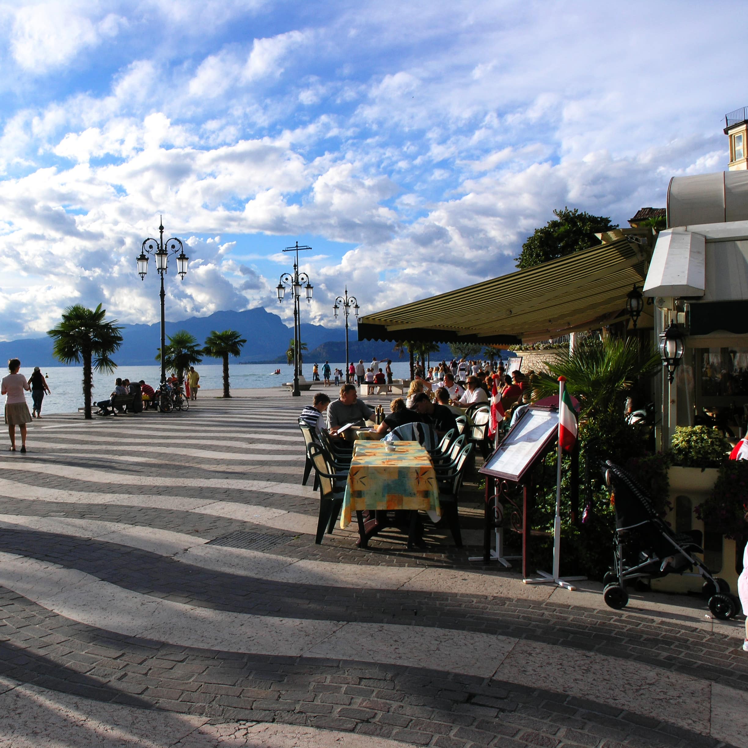 Ein Restaurant an der Promenade von Lazise am Gardasee. Vor dem Restaurant ein Kinderwagen.
