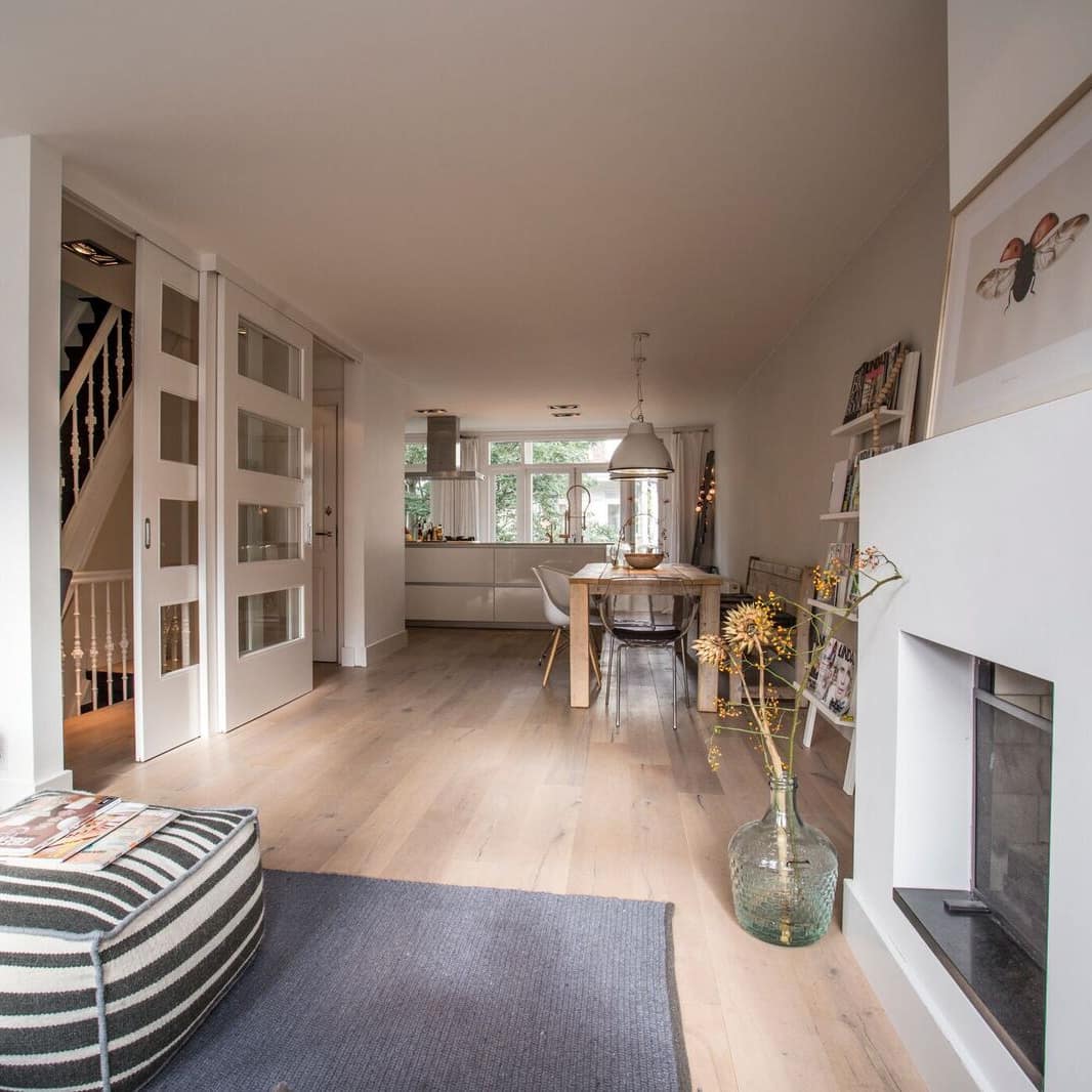 Ferienwohnung in Amsterdam mit großer Wohnküche mit Esstisch, Kamin, Sofa und einer Treppe in den oberen Stock