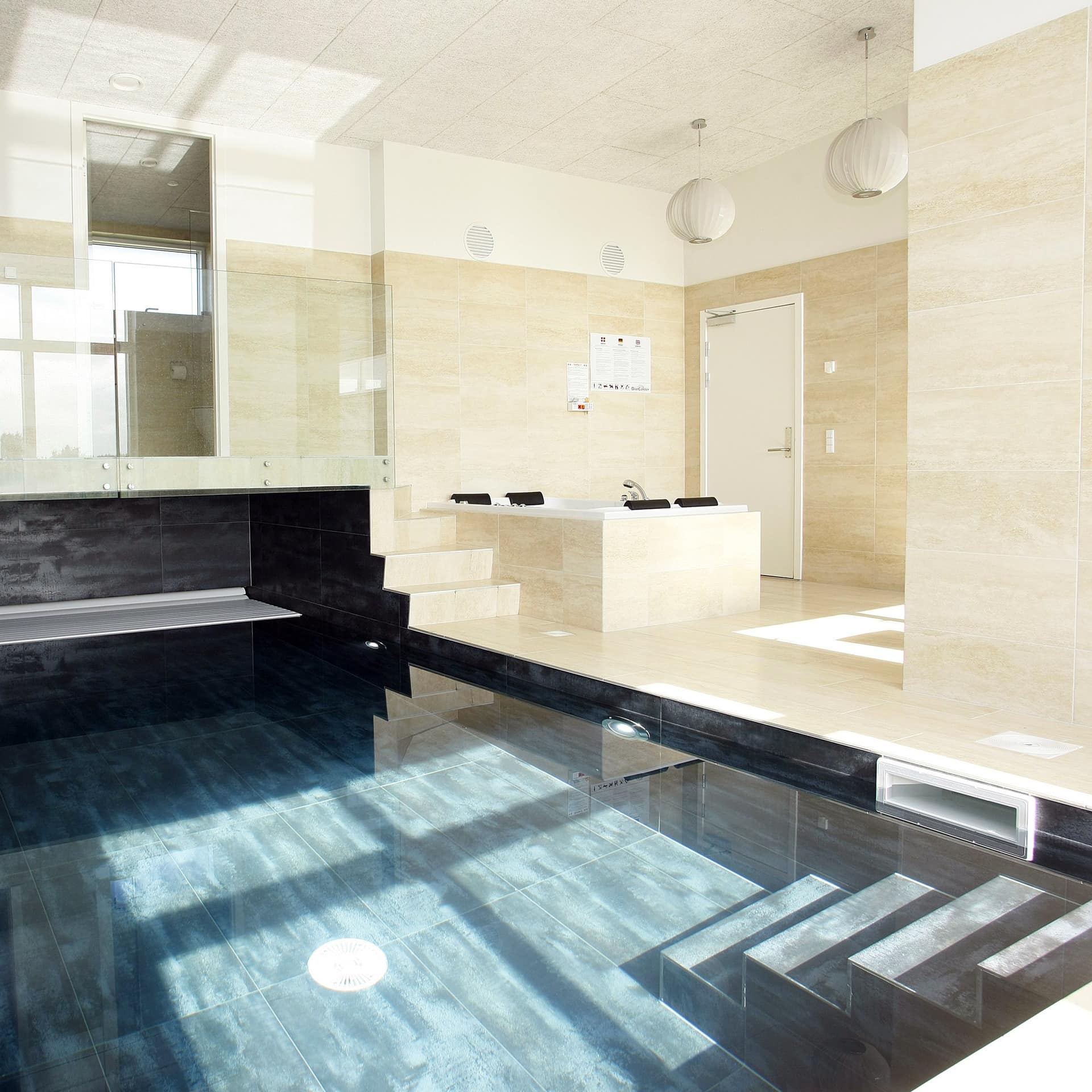 Ein Innenpool eines Luxus-Ferienhauses in Dänemark, auch ein Jacuzzi ist zu sehen.