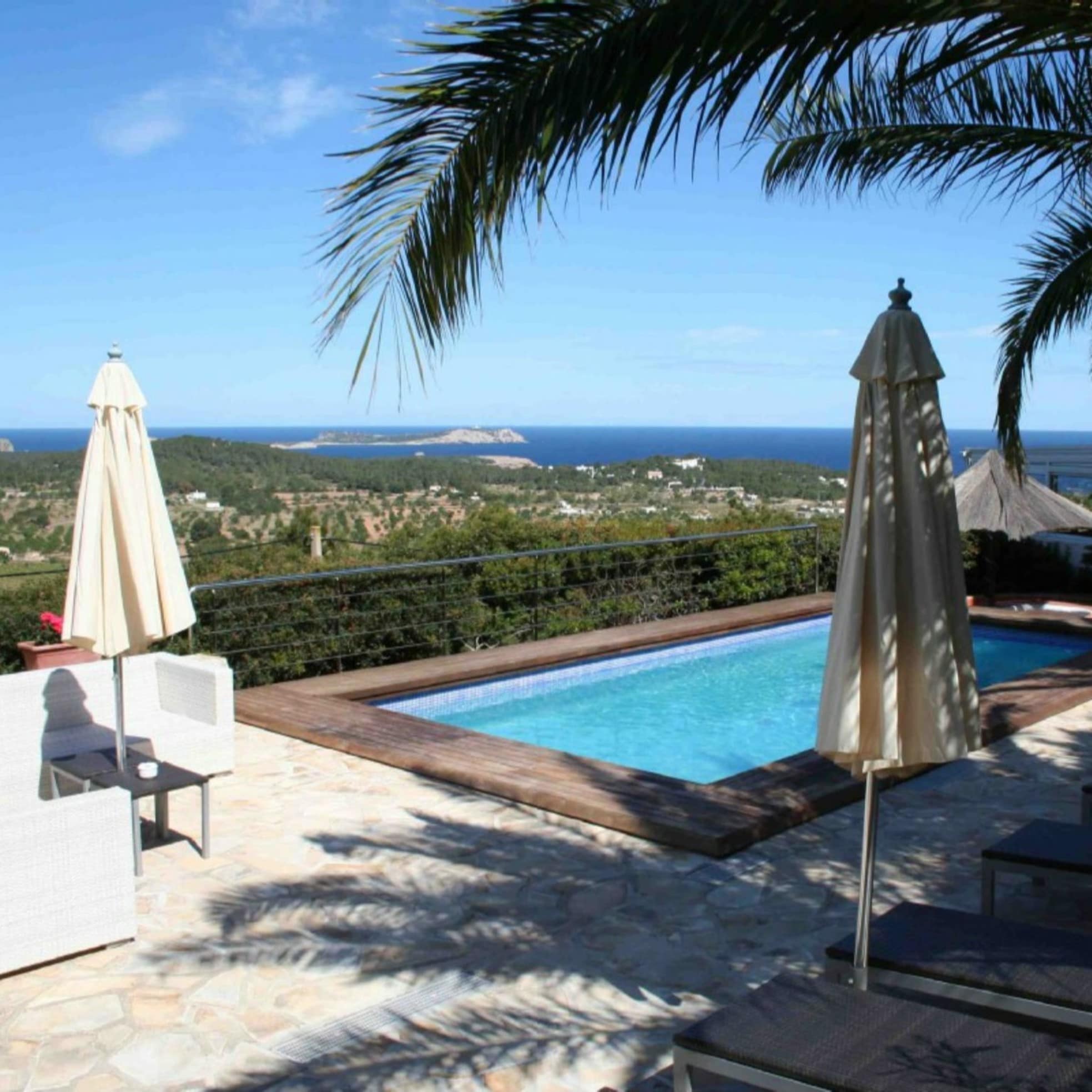 Blick auf Umland und Meer von der Terrasse mit Pool und Sonnenliegen einer Finca auf Ibiza