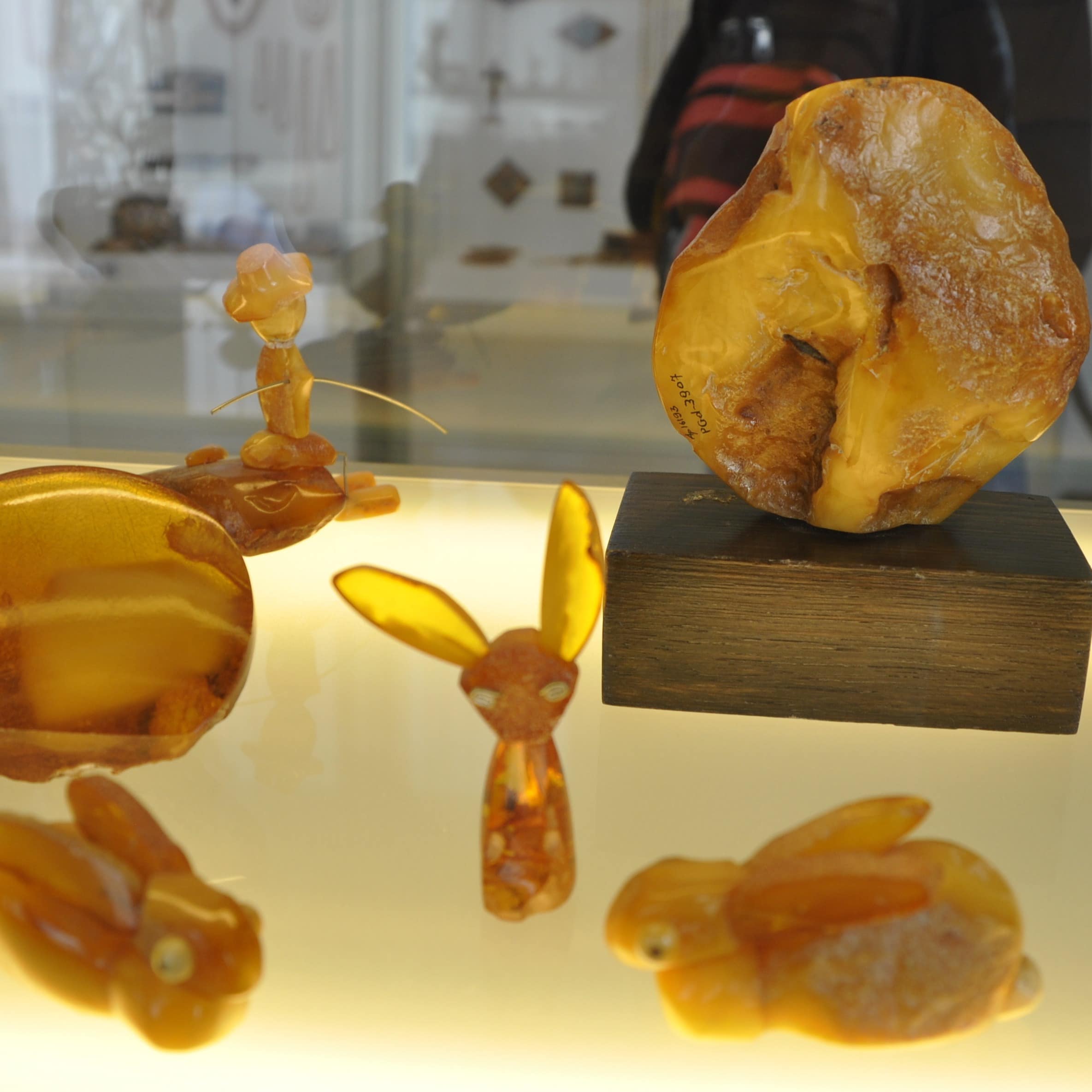 Kleine Tierfiguren und andere Kunst aus Bernstein in einem Museum.