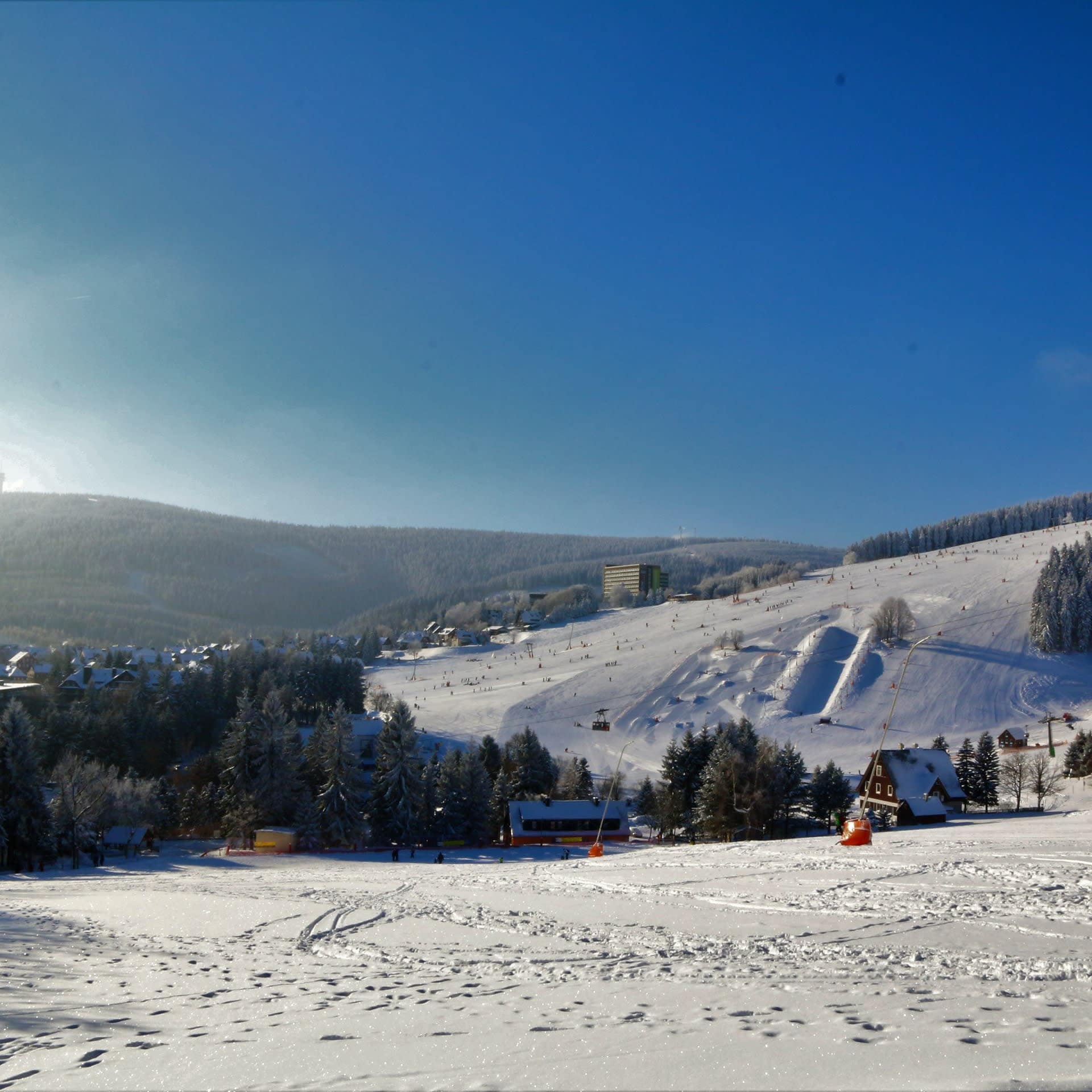 Blick über die verschneite Landschaft mit Häusern und Bäumen