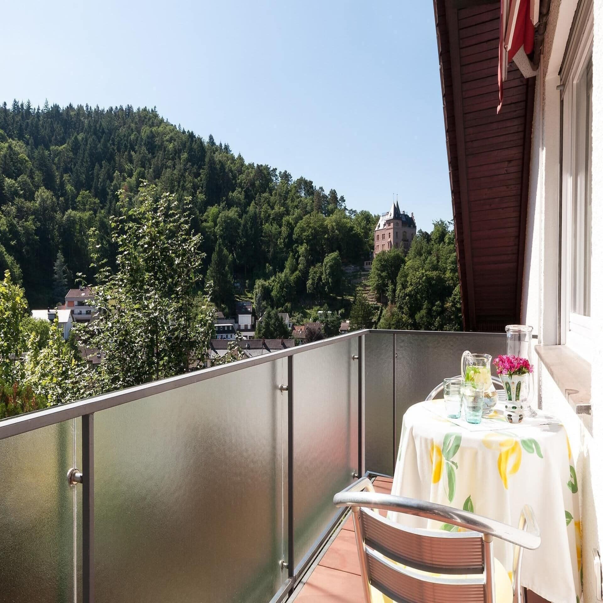 Balkon mit Tisch für 2 Personen und Blick auf einen Ort.