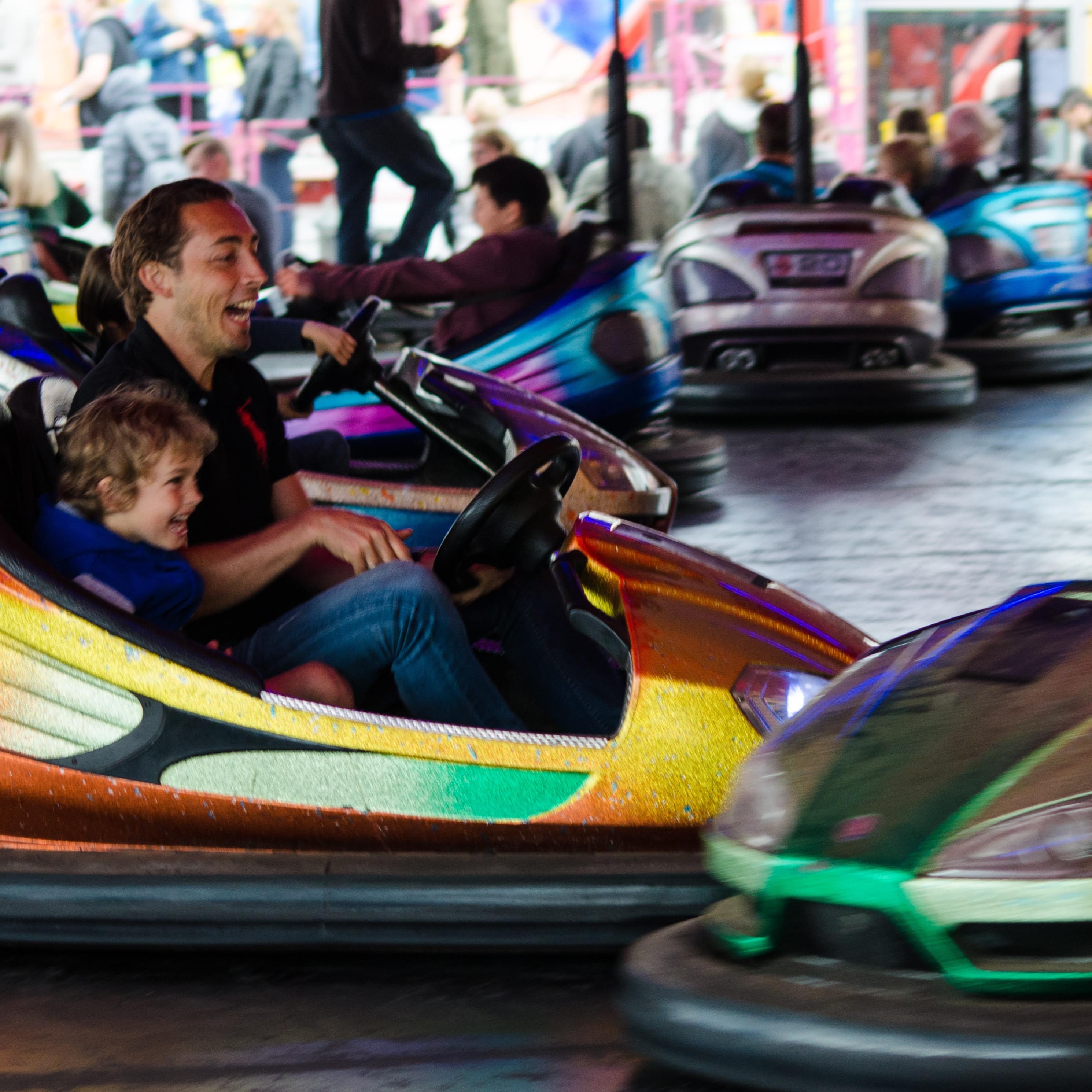 Erwachsene und Kinder beim Autoscooter