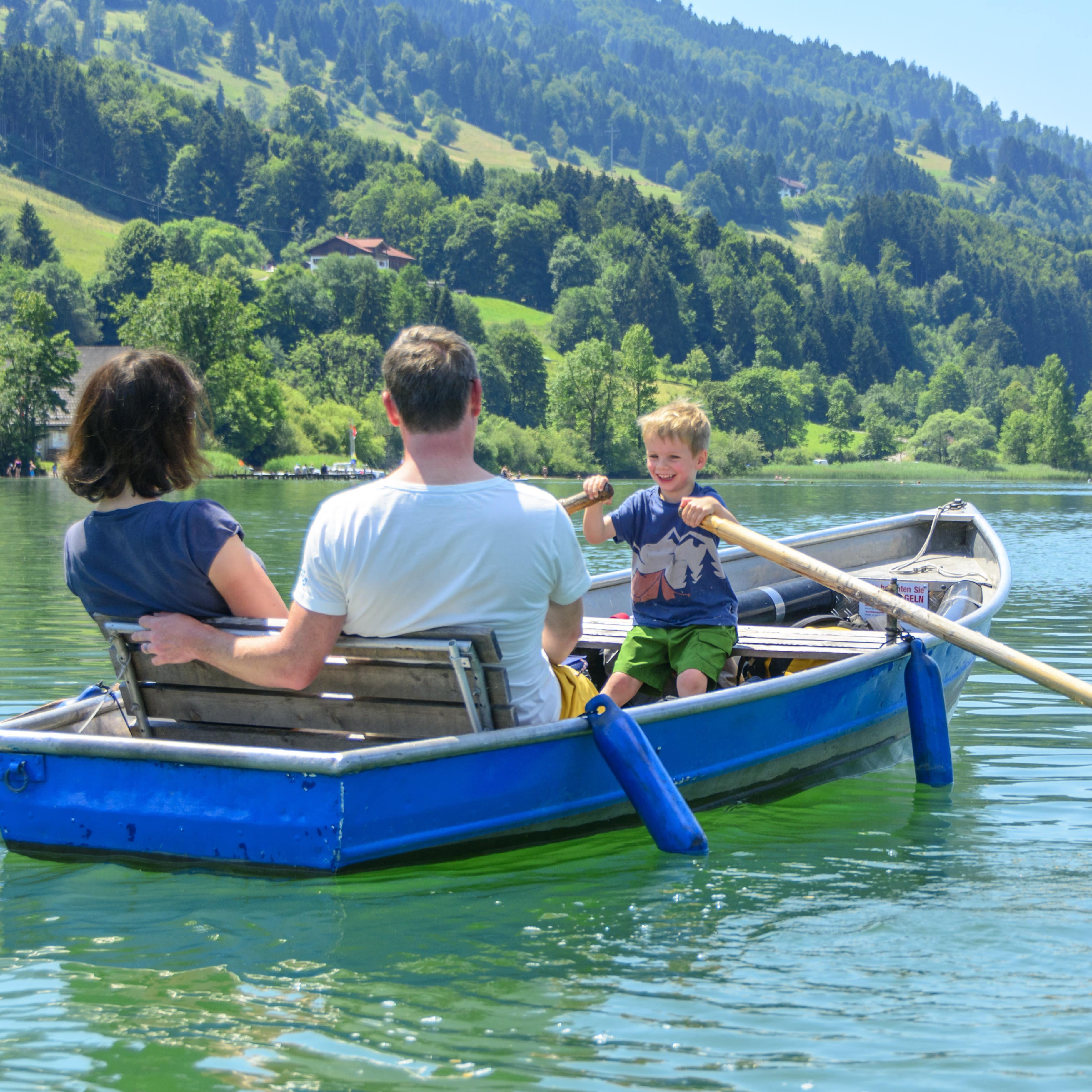 Eltern mit ihrem Sohn beim Bootfahren auf einem See