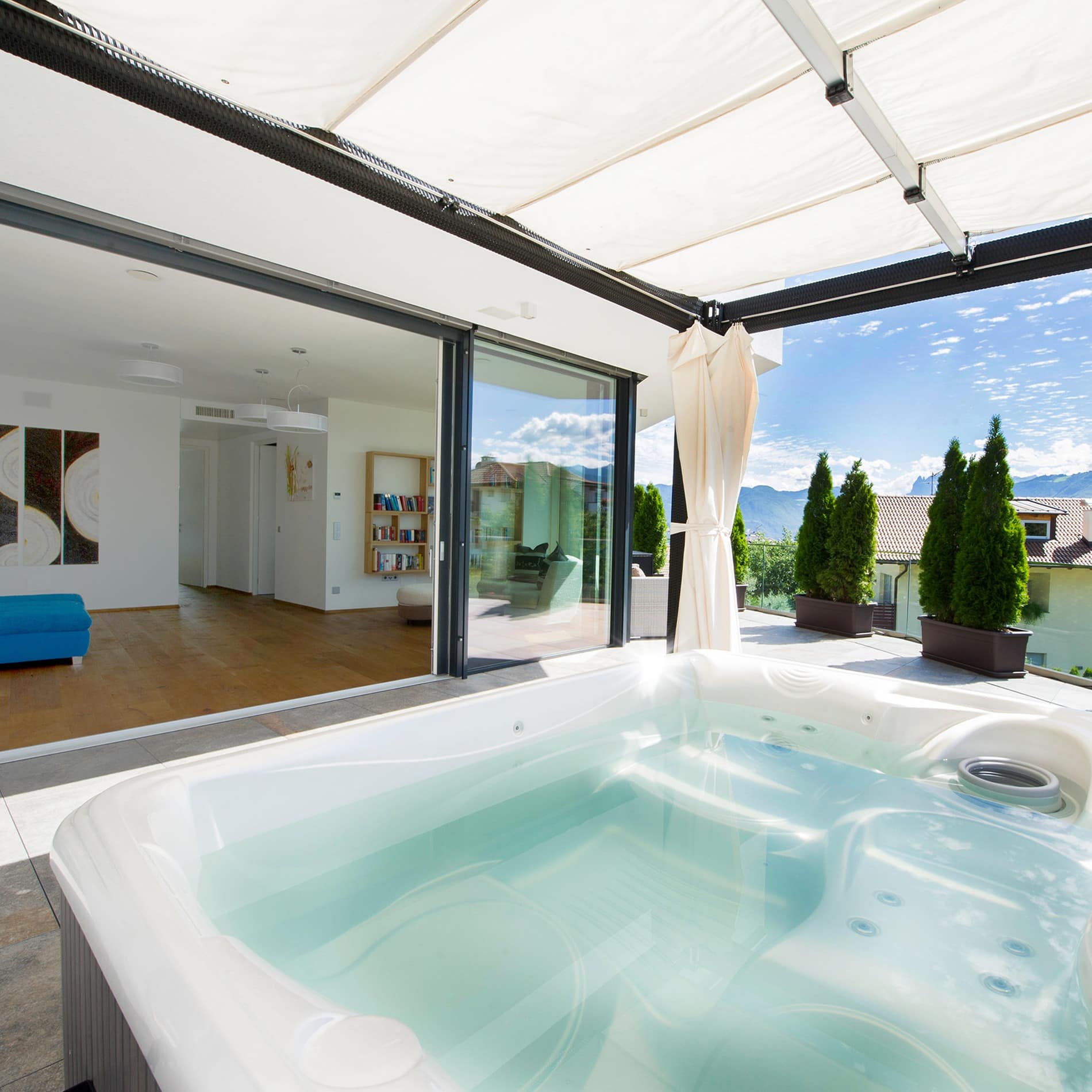 Ein Whirlpool auf der großzügigen Terrasse unter einem Sonnendach zeichnet die Luxus-Ferienwohnung in Meran aus