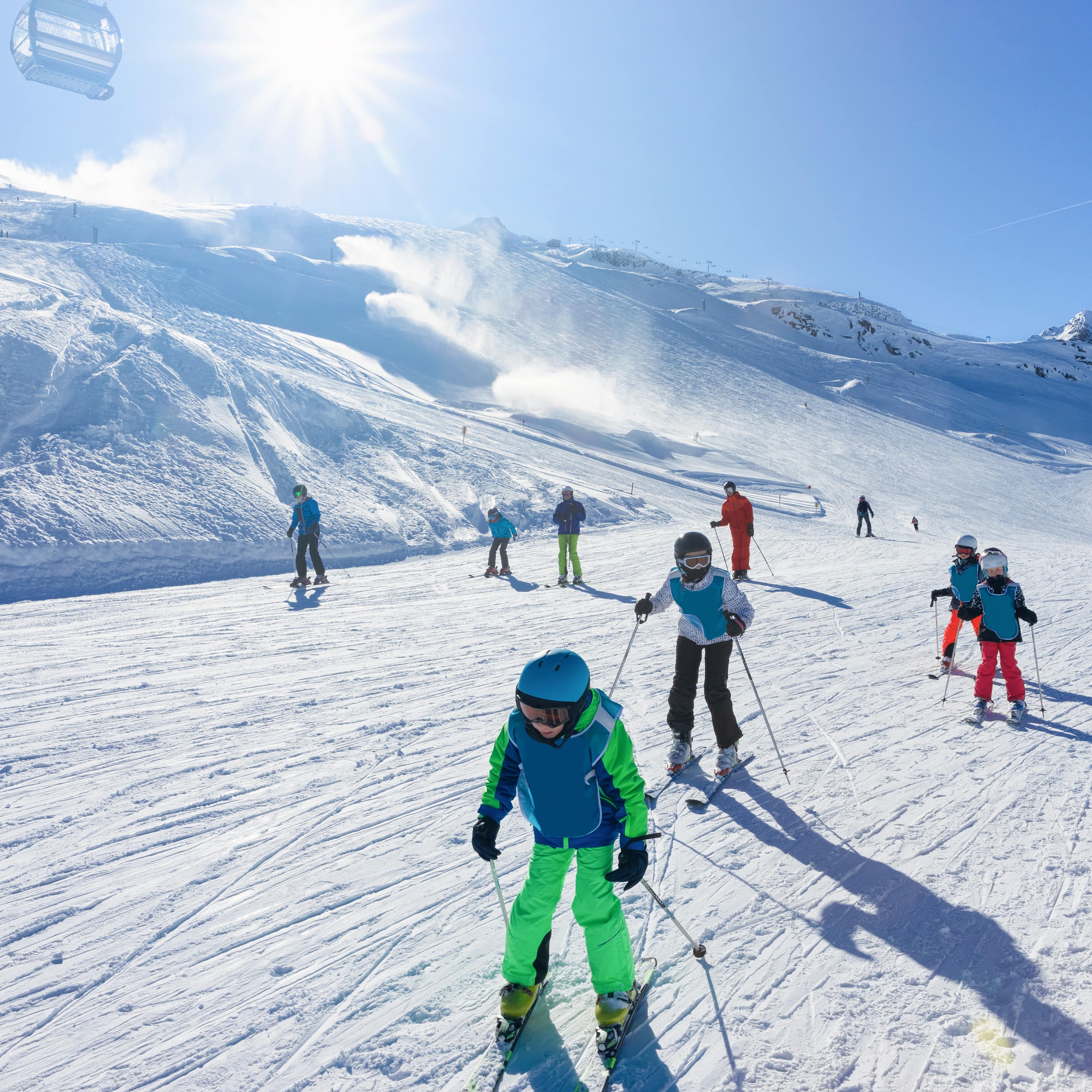 Kinder und Erwachsene auf einer Skipiste