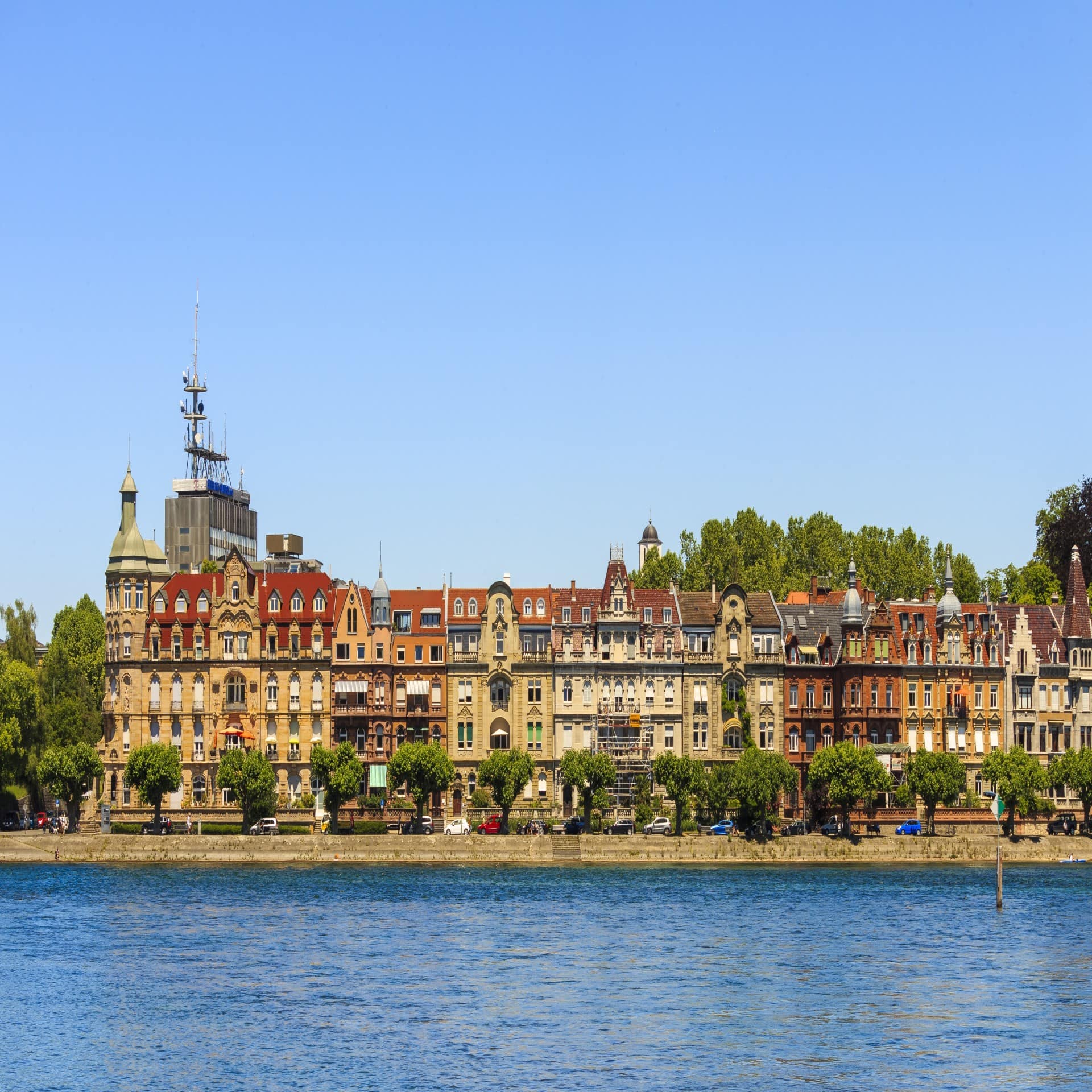 Blick vom Bodensee auf die Altstadt von Konstanz. Der Himmel ist blau.