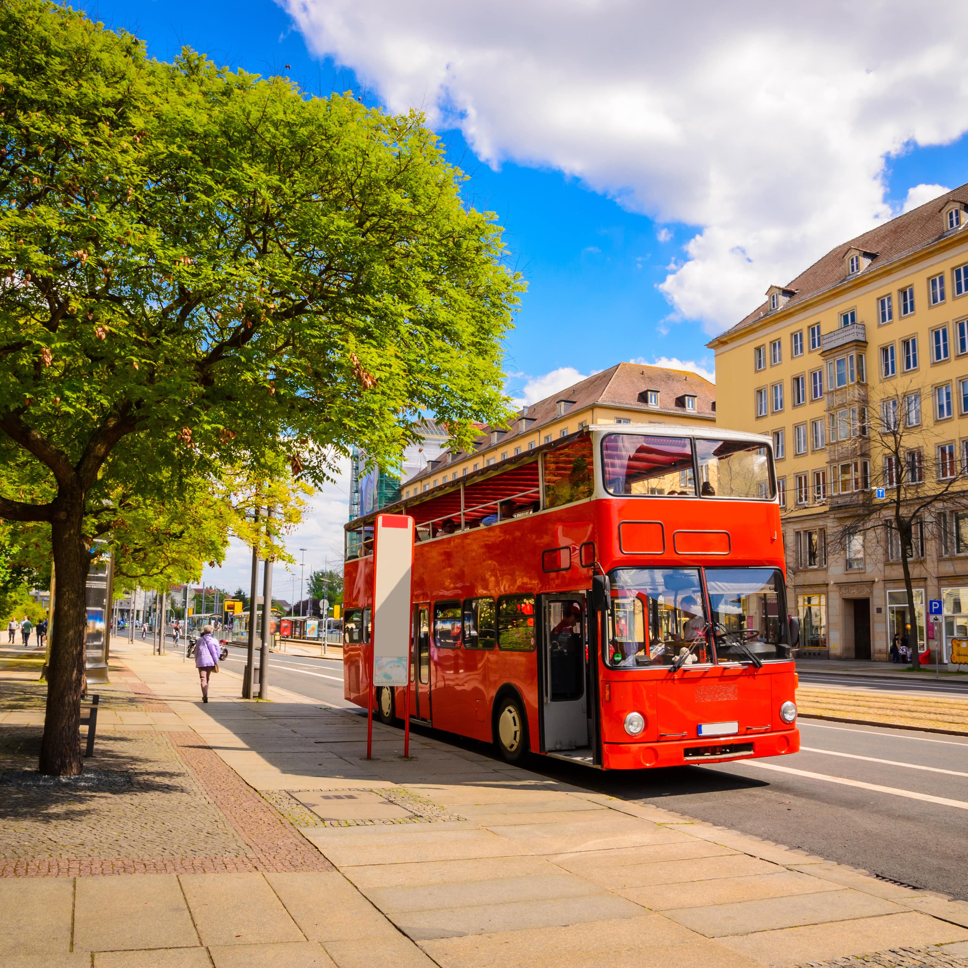 Roter Doppeldeckerbus an einer Haltestelle in Dresden.