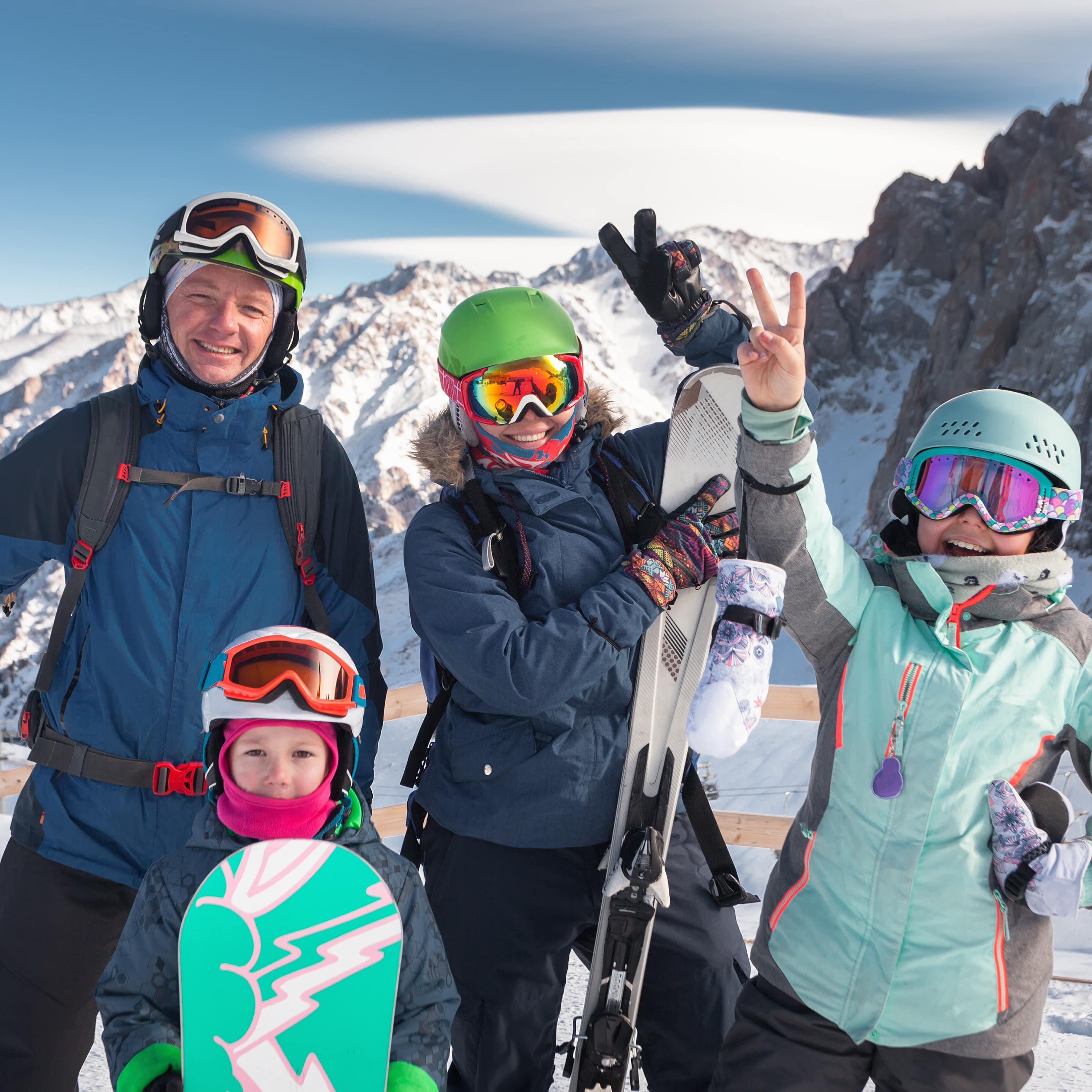 Eine Familie mit Snowboards vor der Kulisse der Berge