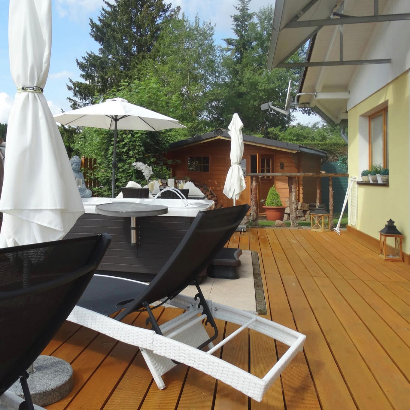 Terrasse mit Jacuzzi und Sonnenliegen eines Ferienhauses am Schluchsee