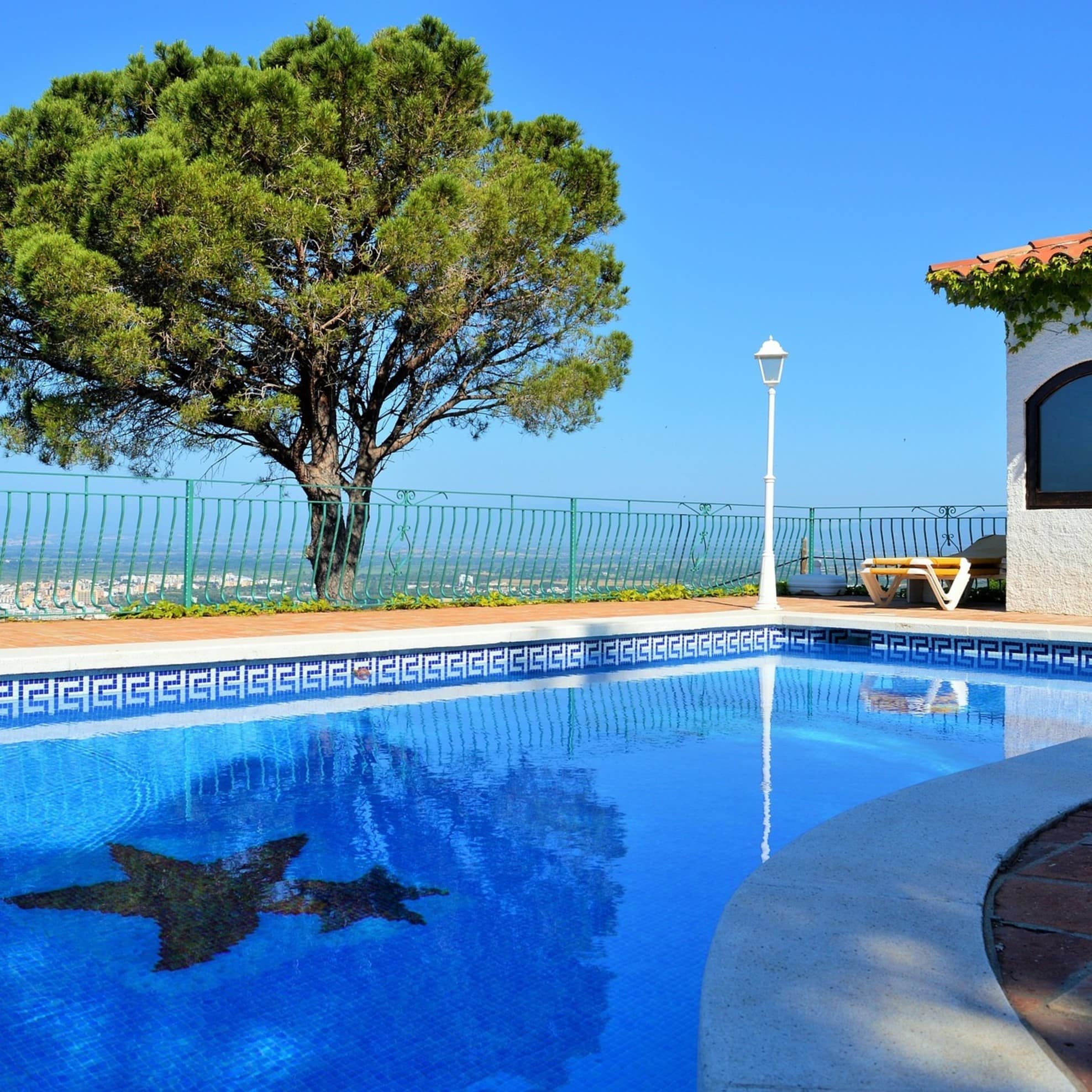Blick auf einen Pool und Baum in einem Garten mit Aussicht auf das Umland
