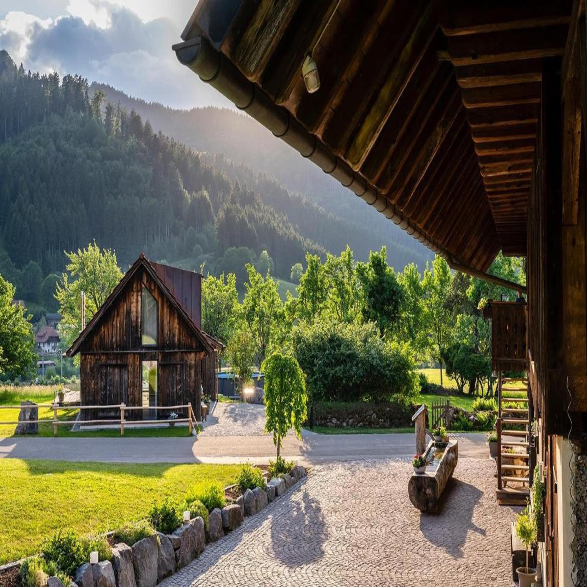 Bauernhaus mit umgebauter Scheune mit Pool umgeben von Wiesen und Wäldern. 