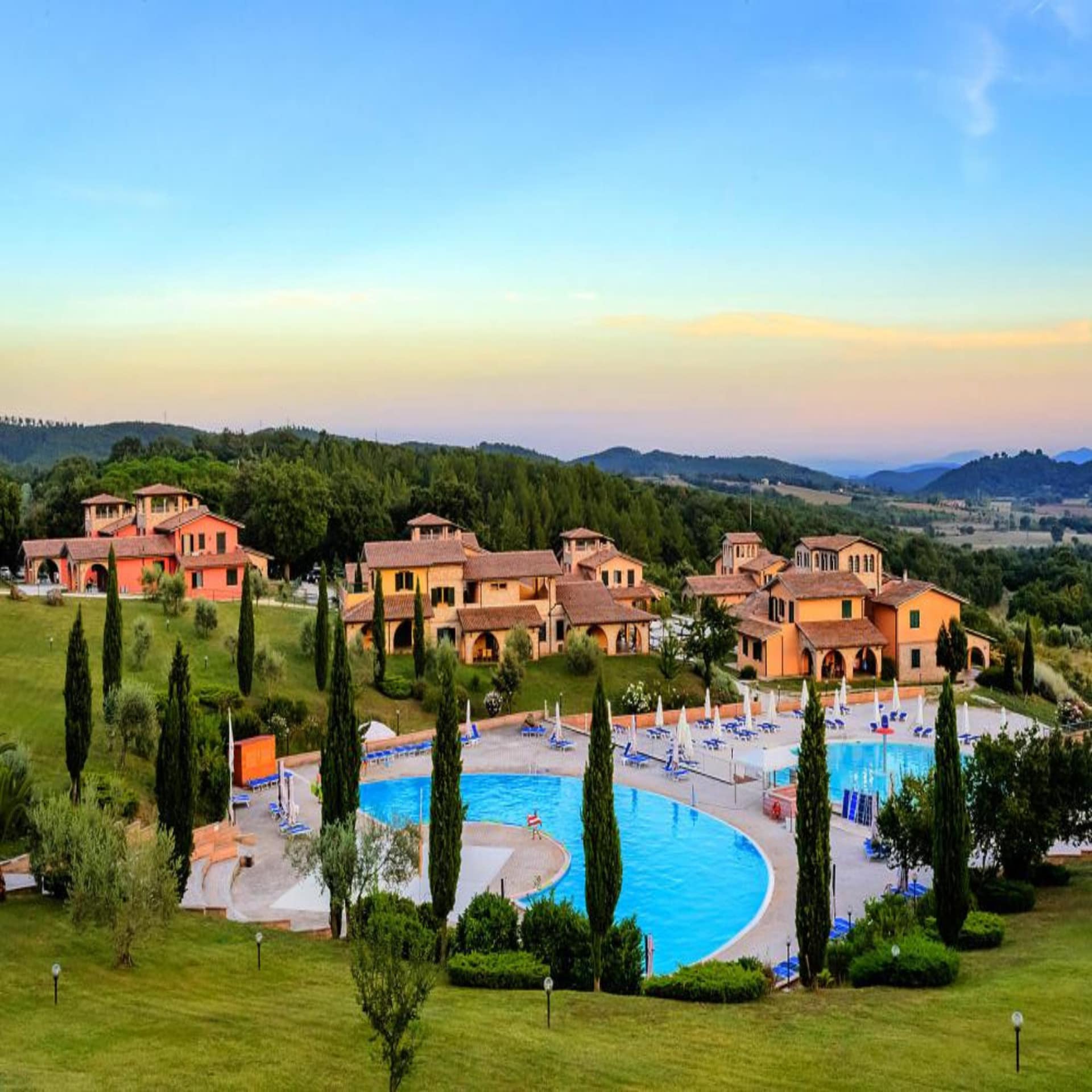 Panoramablick auf mediterrane Häuser eines Ferienparks mit großer Poollandschaft. 