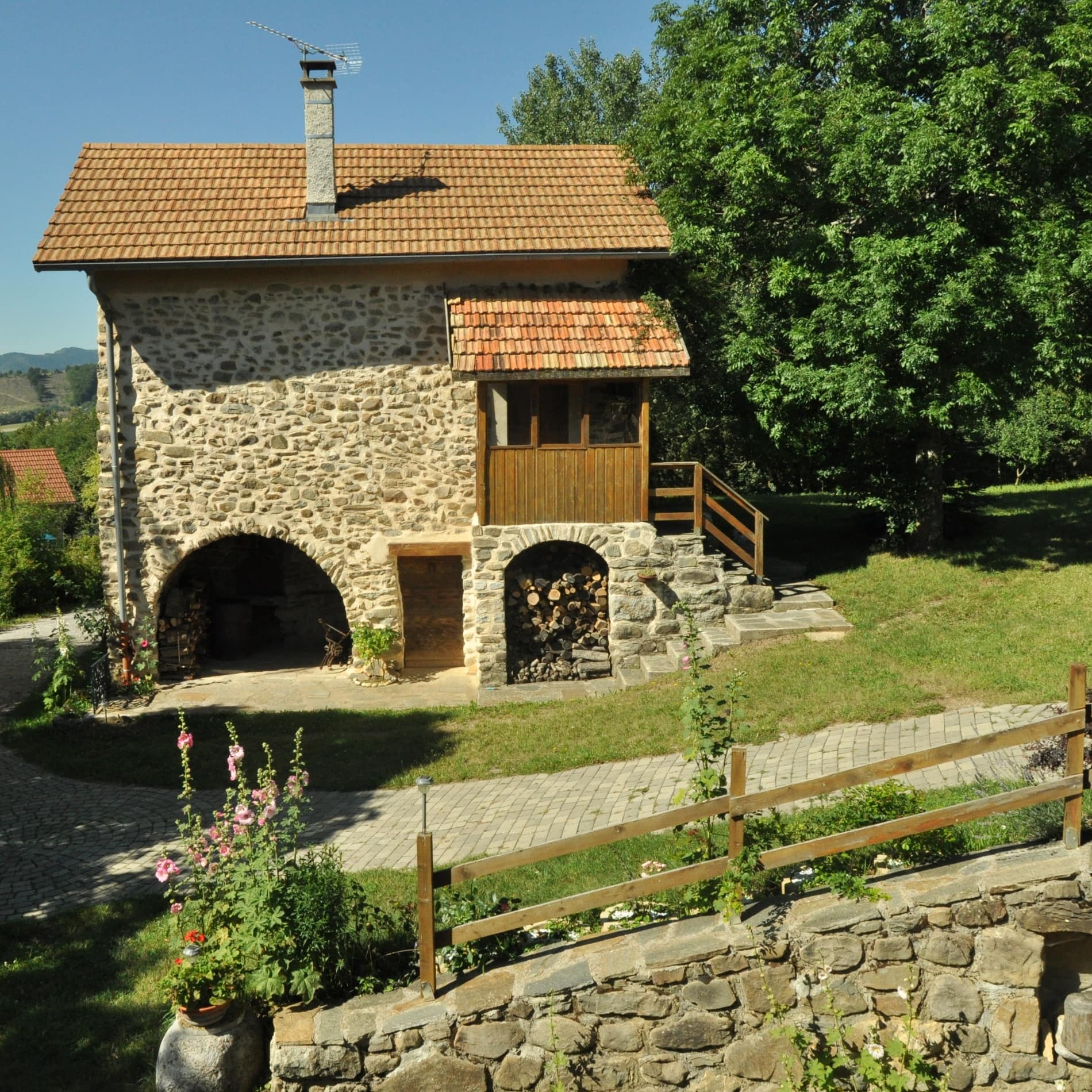 Altes Haus mit Wänden aus unbehauenen Steinen in einem Garten