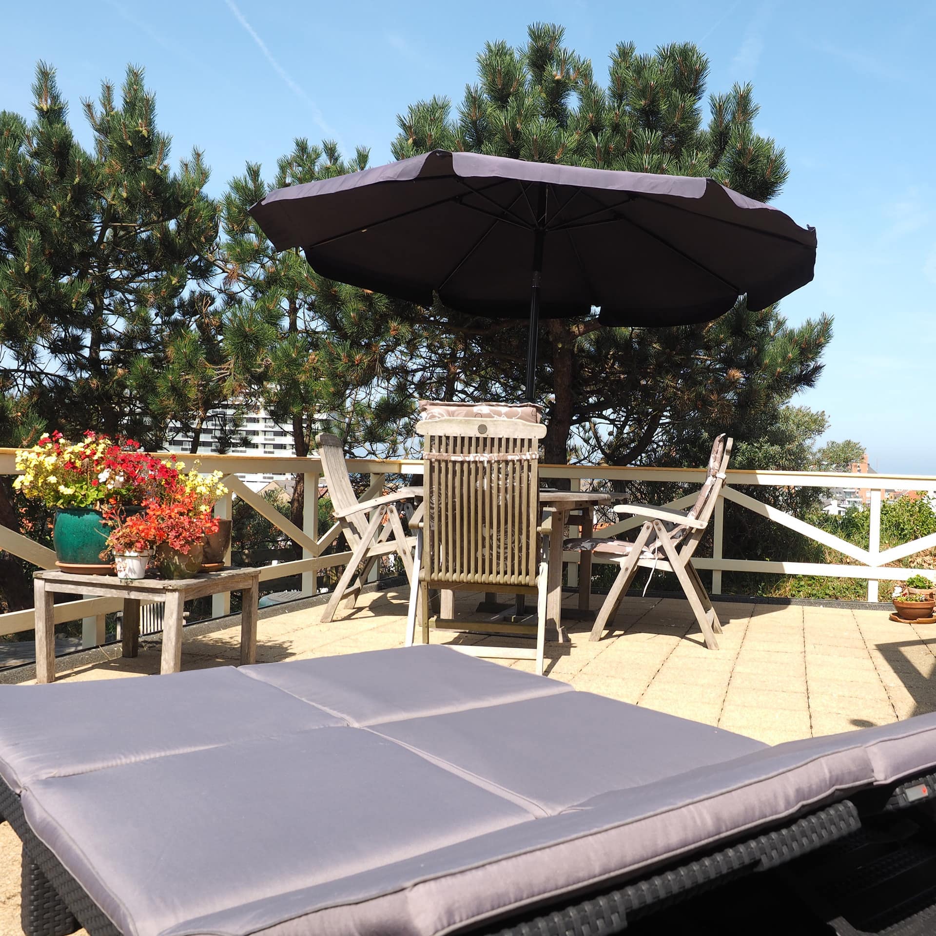 Ferienwohnung in Egmond aan Zee mit großer Terrasse, Liege, Stühlen und Blick über den Ort