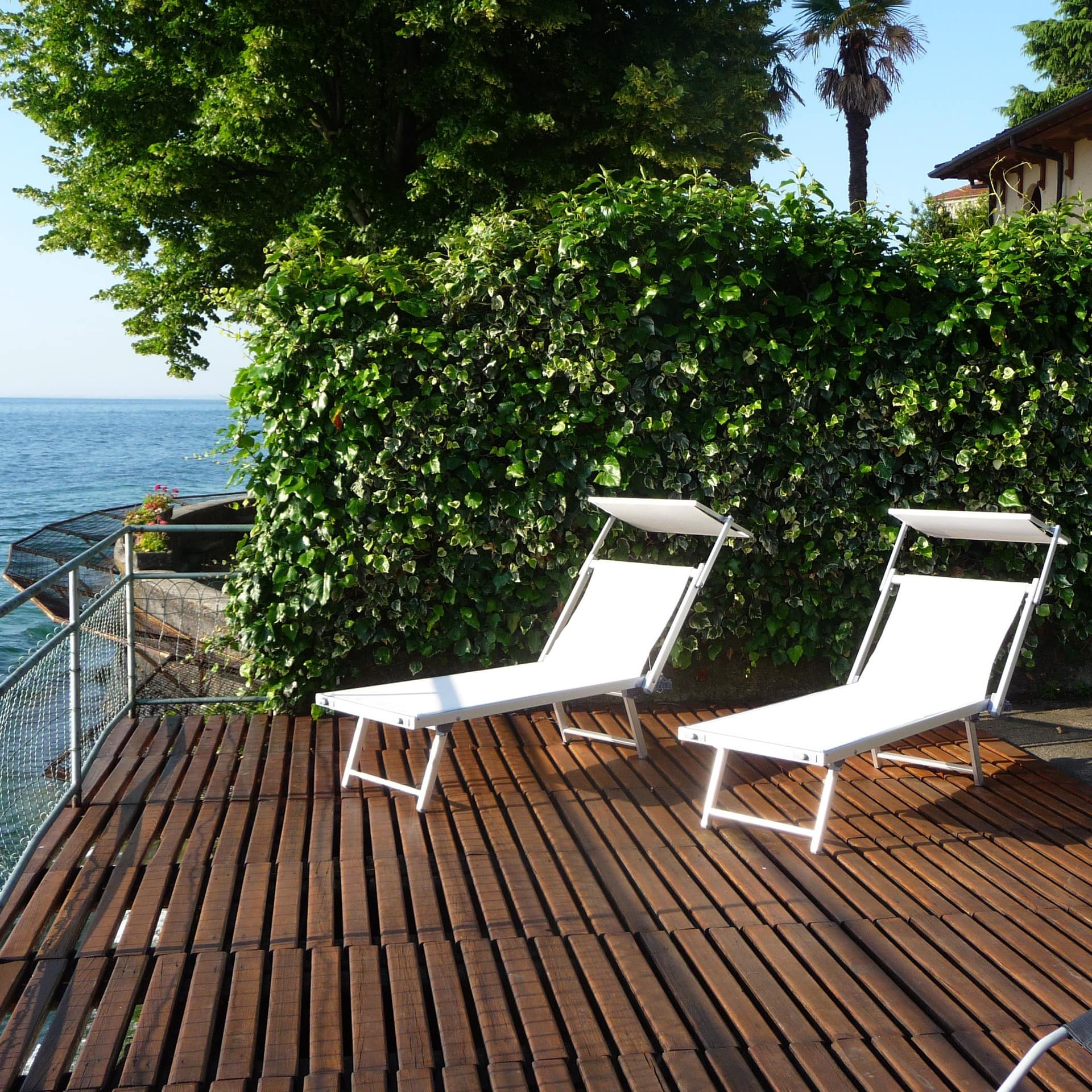 Sonnendeck mit Liegestühlen eines Ferienhauses direkt am Gardasee